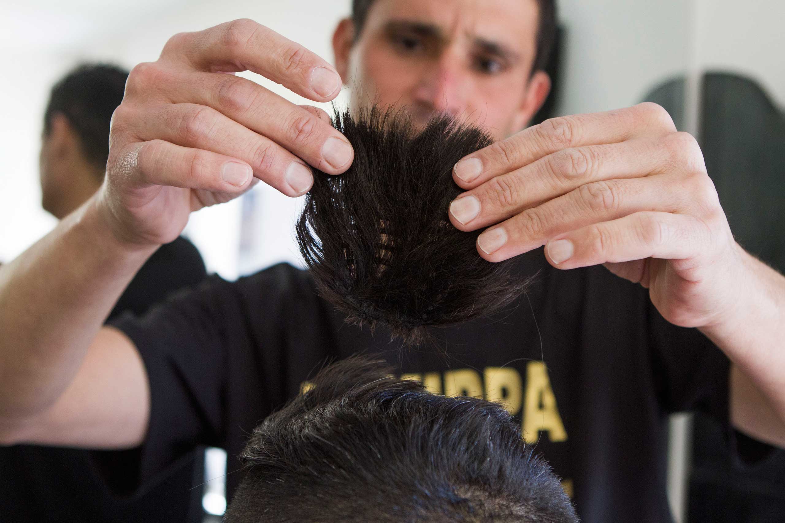 Israeli hairdresser Shalom Koresh places a yarmulke, a skullcap made of hair samples, on a man's head in the city of Rehovot, Israel on Jan. 21, 2015.