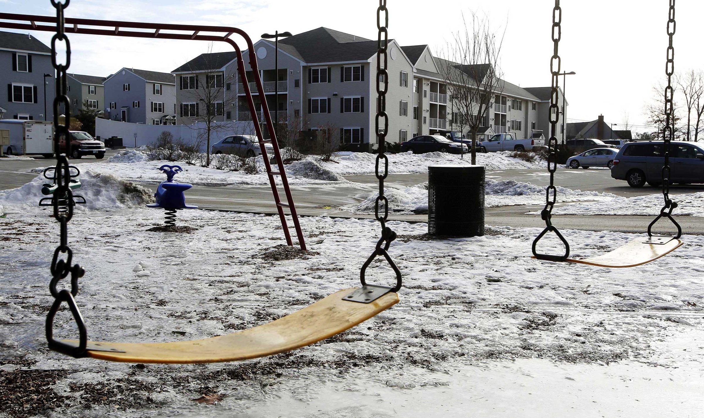 An empty playground is seen at an apartment complex, Jan. 22, 2015, in Manchester, N.H. where authorities say twin 9-year-old boys were left mostly alone for four months after their parents took three siblings to Nigeria and left an uncle to care for them.
