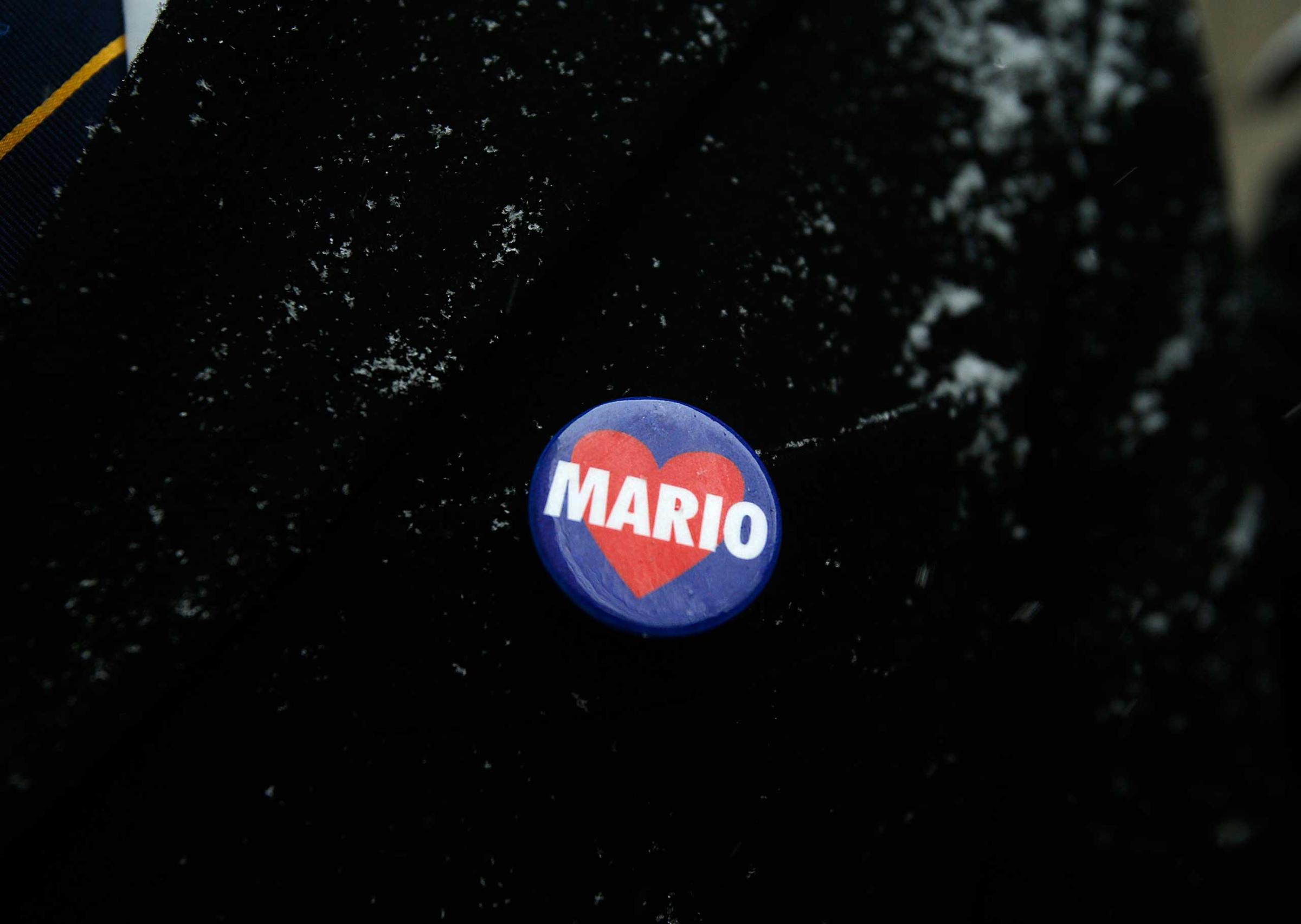 A mourner wears a Mario Cuomo button while waiting in line to enter St. Ignatius Loyola Church, before the funeral service for the former New York governor in New York