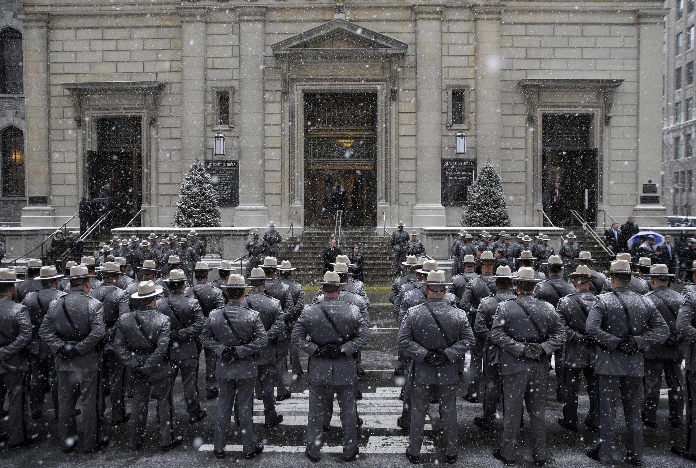 State troopers stand at attention in the snow before the funeral for former New York governor Mario Cuomo at Church of St. Ignatius Loyola in New York on Jan. 6, 2015.