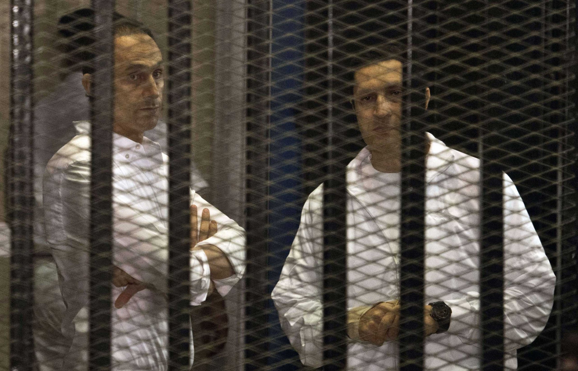 The sons of ousted Egyptian president Hosni Mubarak, Gamal and Alaa behind the defendants' cage during their retrial at the Police Academy in Cairo in 2013.