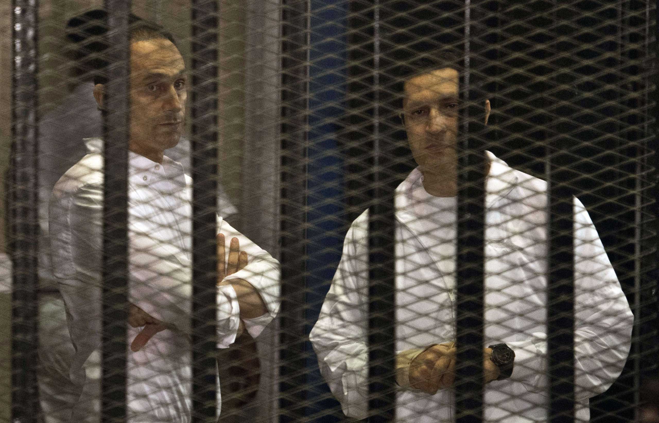 The sons of ousted Egyptian president Hosni Mubarak, Gamal and Alaa  behind the defendants' cage during their retrial at the Police Academy in Cairo in 2013. (Khaled Desouki—AFP/Getty Images)