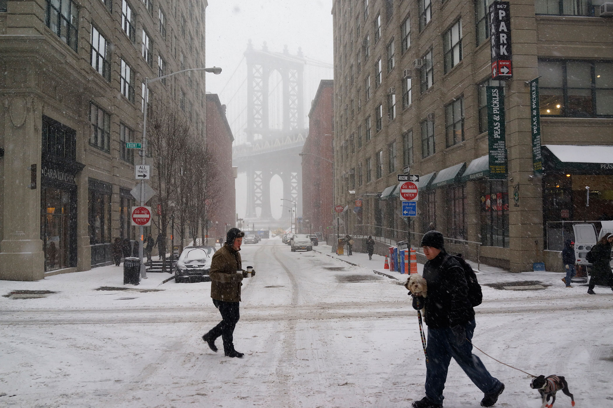 People walk in front of the Manhattan Bridge in the DUMBO neighborhood as it snows in Brooklyn, NY on Jan. 26, 2015Photograph by Andrew Hinderaker