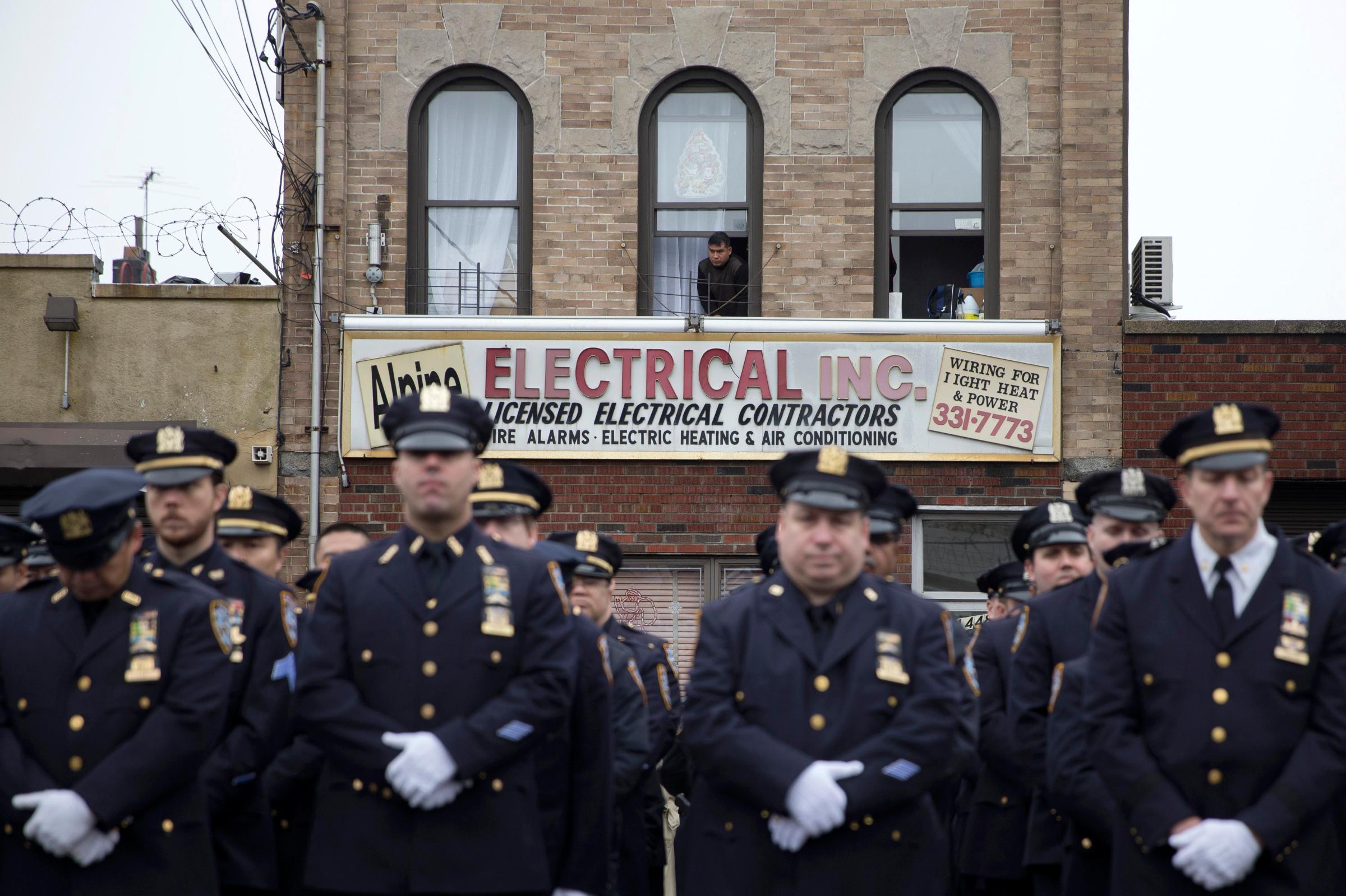 A spectator looks out onto officers during the funeral of New York Police Department Officer Wenjian Liu at Aievoli Funeral Home on Jan. 4, 2015 in the Brooklyn borough of New York.