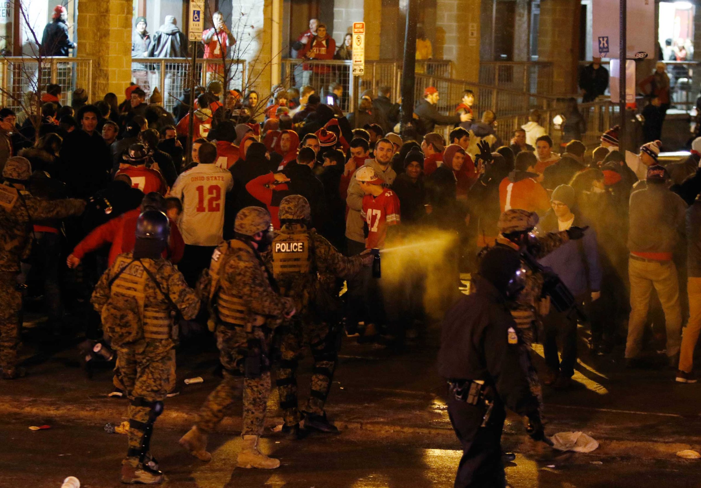 Police officers try to disperse the crowd of Ohio State fans trying to block High Street in Columbus, Ohio, as they celebrate the Buckeye's 42-20 win over Oregon following the National Championship football game between Ohio State and Oregon, Jan. 12, 2015.