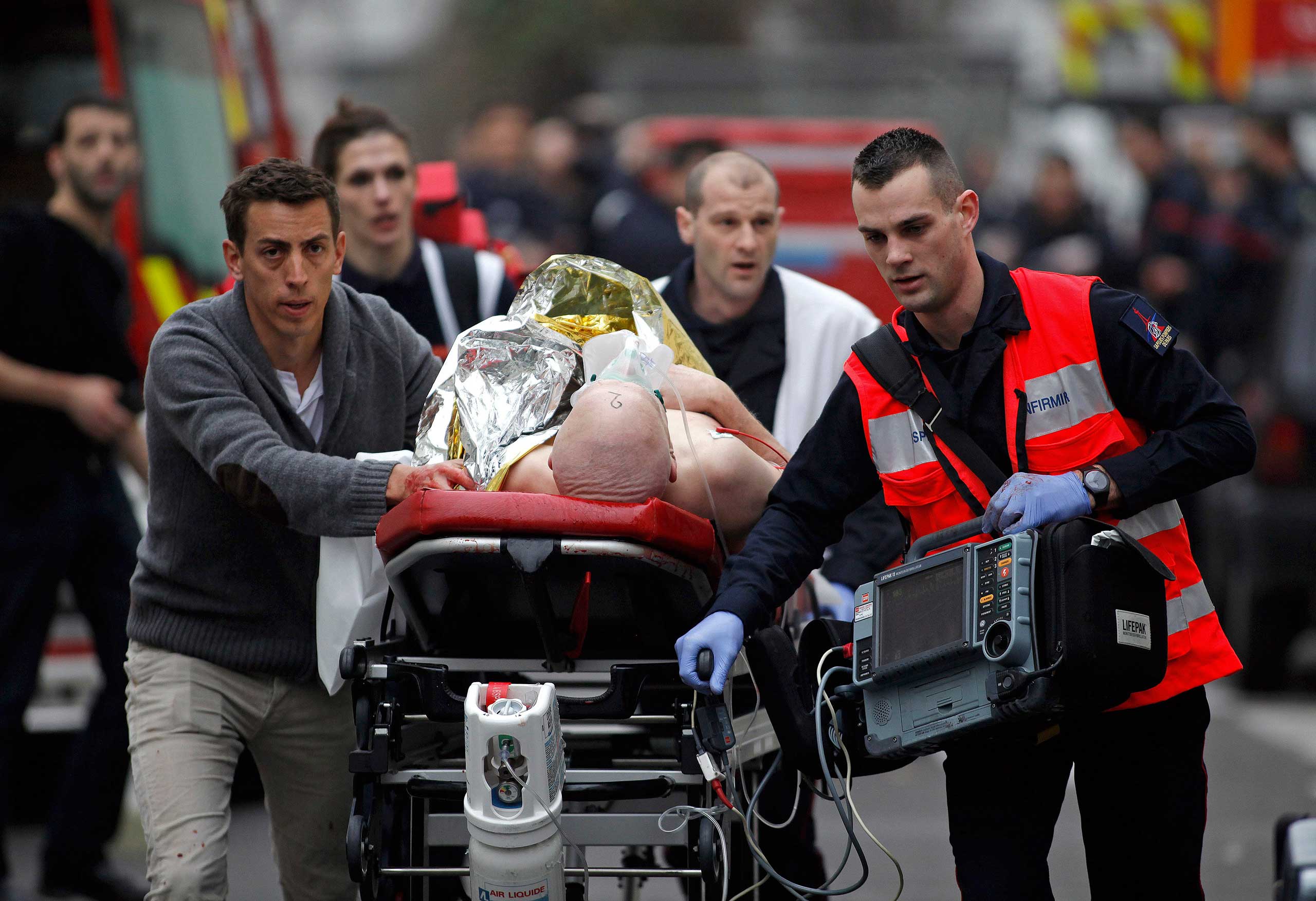 An injured person is evacuated outside the French satirical magazine Charlie Hebdo's office, in Paris, Jan. 7, 2015. (Thibault Camus—AP)