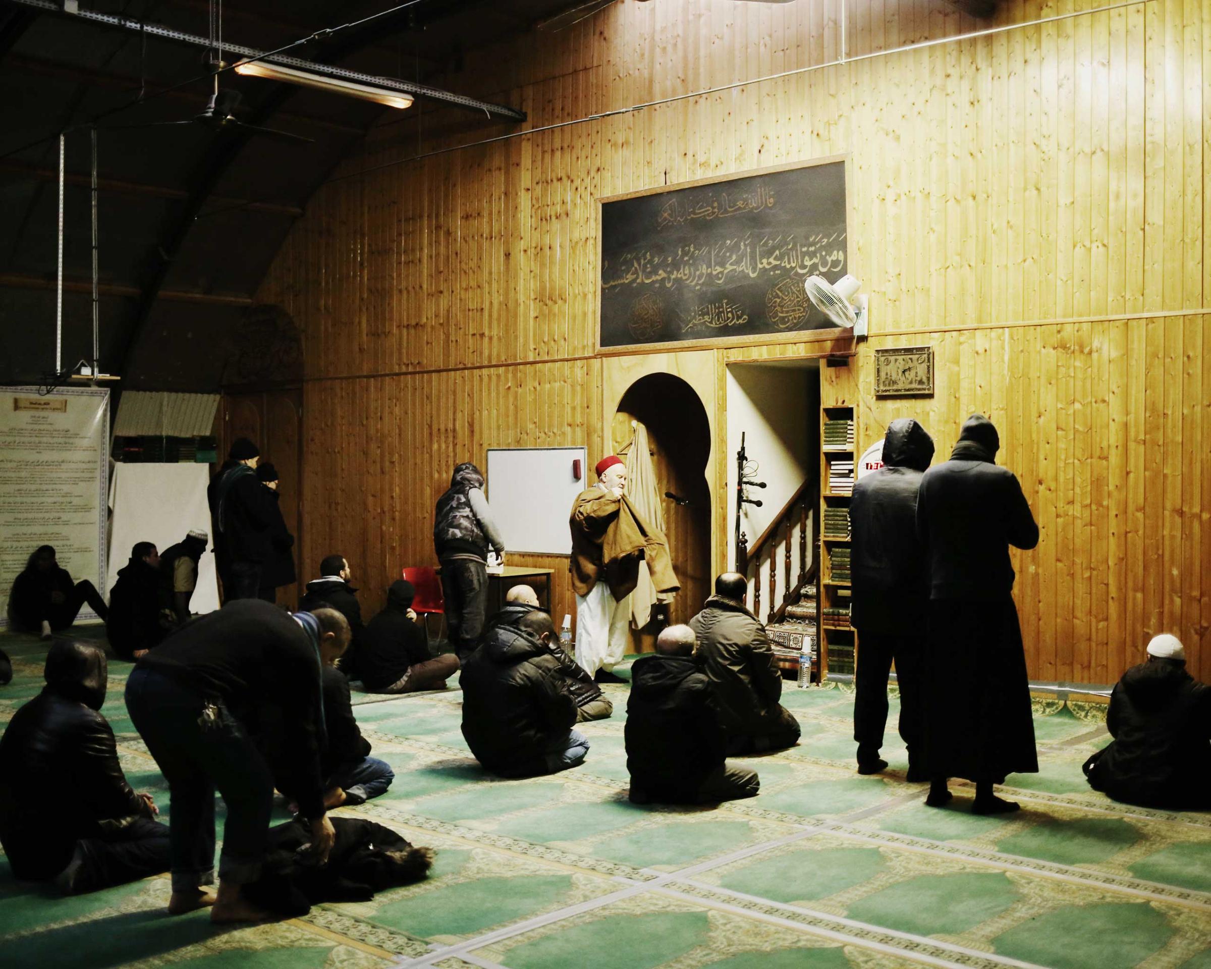 Men pray at a mosque in the 19th arrondissement in Paris, which the Kouachi brothers, the Charlie Hebdo attackers, had once attended, Jan. 13, 2015.