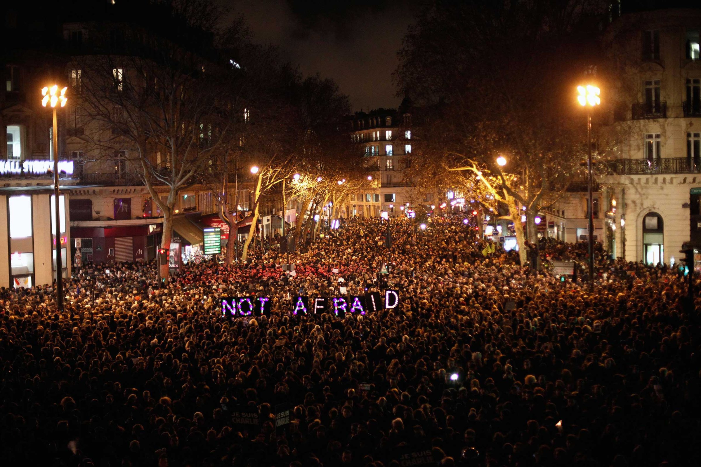 People gather to pay respect for the victims of a terror attack against a satirical newspaper, in Paris, Jan. 7, 2015.