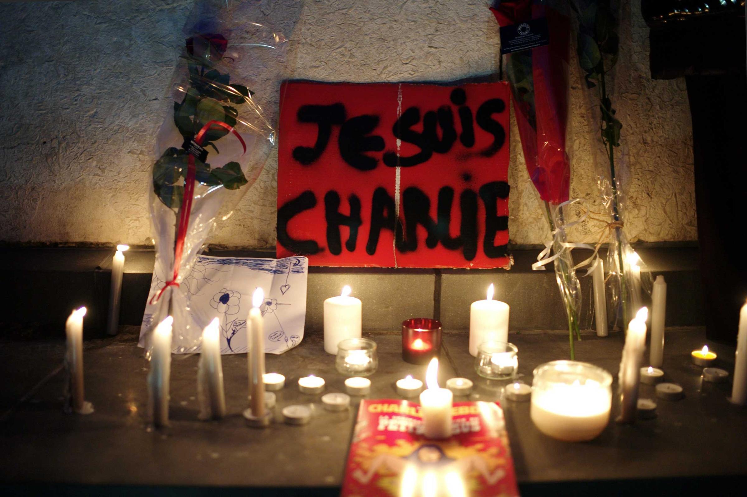A banner reading "I am Charlie" is displayed with candles during a gathering to pay respect for the victims of a terror attack against a satirical newspaper, in Paris, Jan. 7, 2015.
