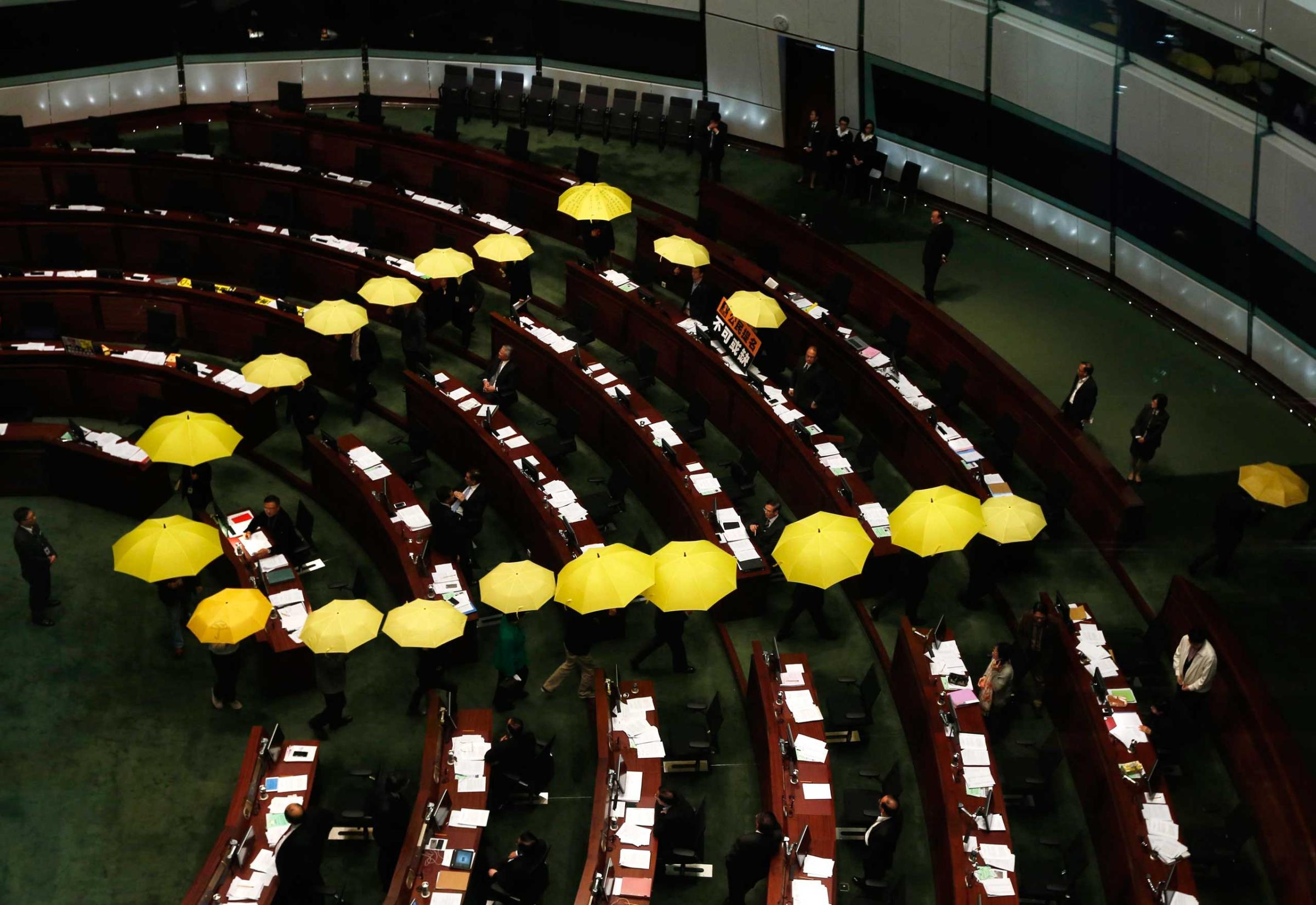 Jan. 7, 2015. Pro-democracy lawmakers carrying yellow umbrellas, symbols for the Occupy Central movement, leave in the middle of a Legislative Council meeting as a gesture to boycott the government in Hong Kong.