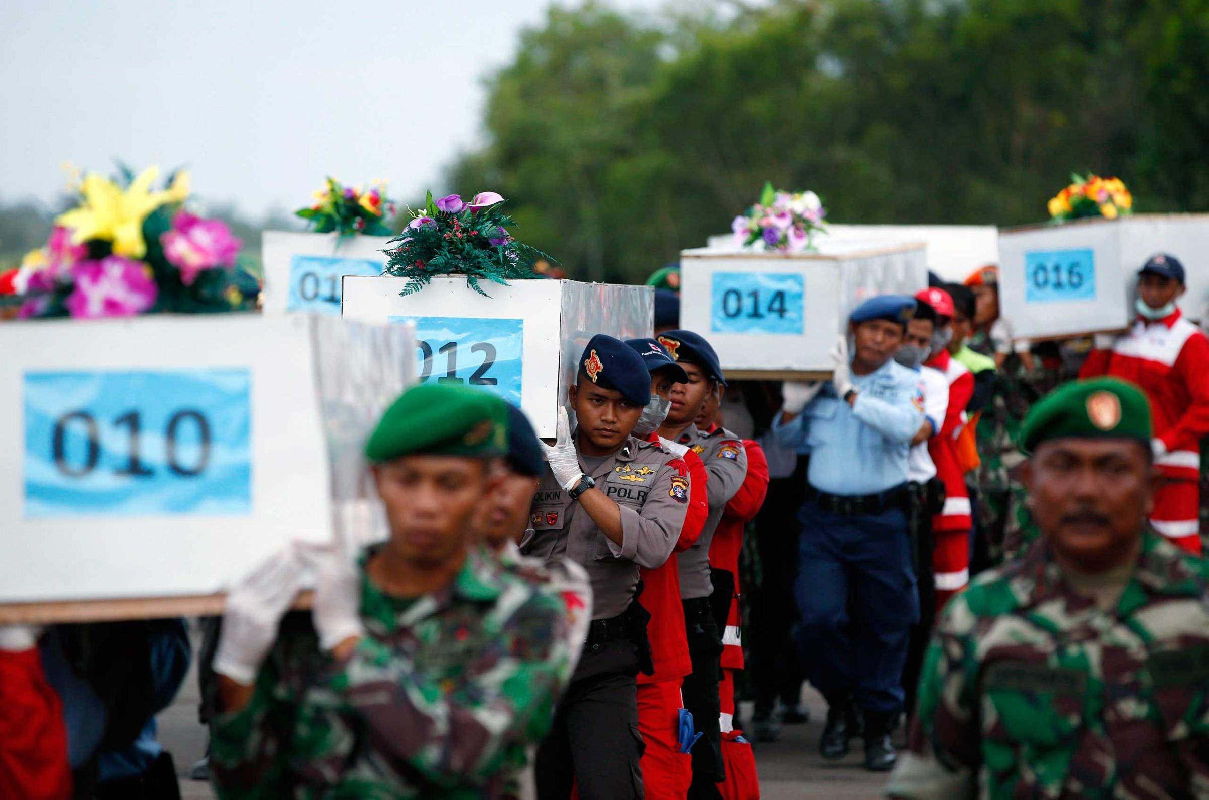 Jan. 2, 2015. Caskets containing the remains of AirAsia QZ8501 passengers recovered from the sea are carried to a military transport plane before being transported to Surabaya, Indonesia.