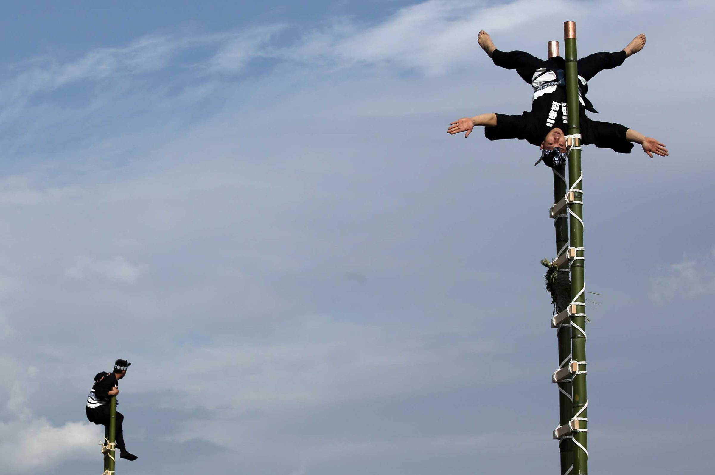 Jan. 6, 2015. Members of a traditional firefighting preservation group perform ladder stunts during the annual New Year's Fire Brigade Review in Tokyo.