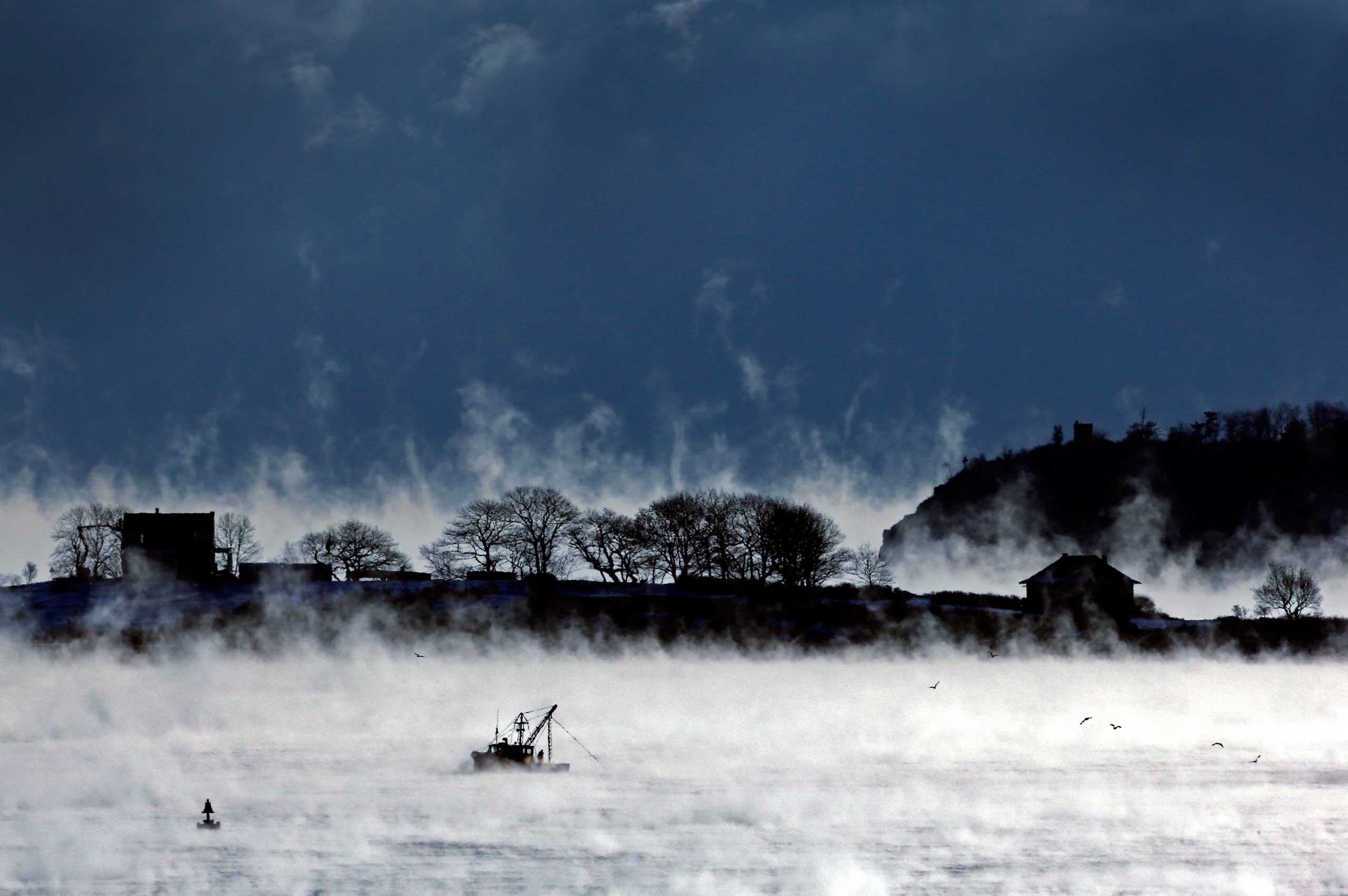 Jan. 8, 2014. A fisherman works aboard a trawler passing House Island in Casco Bay of Portland, Maine, where the temperature at dawn was minus-9 degrees.