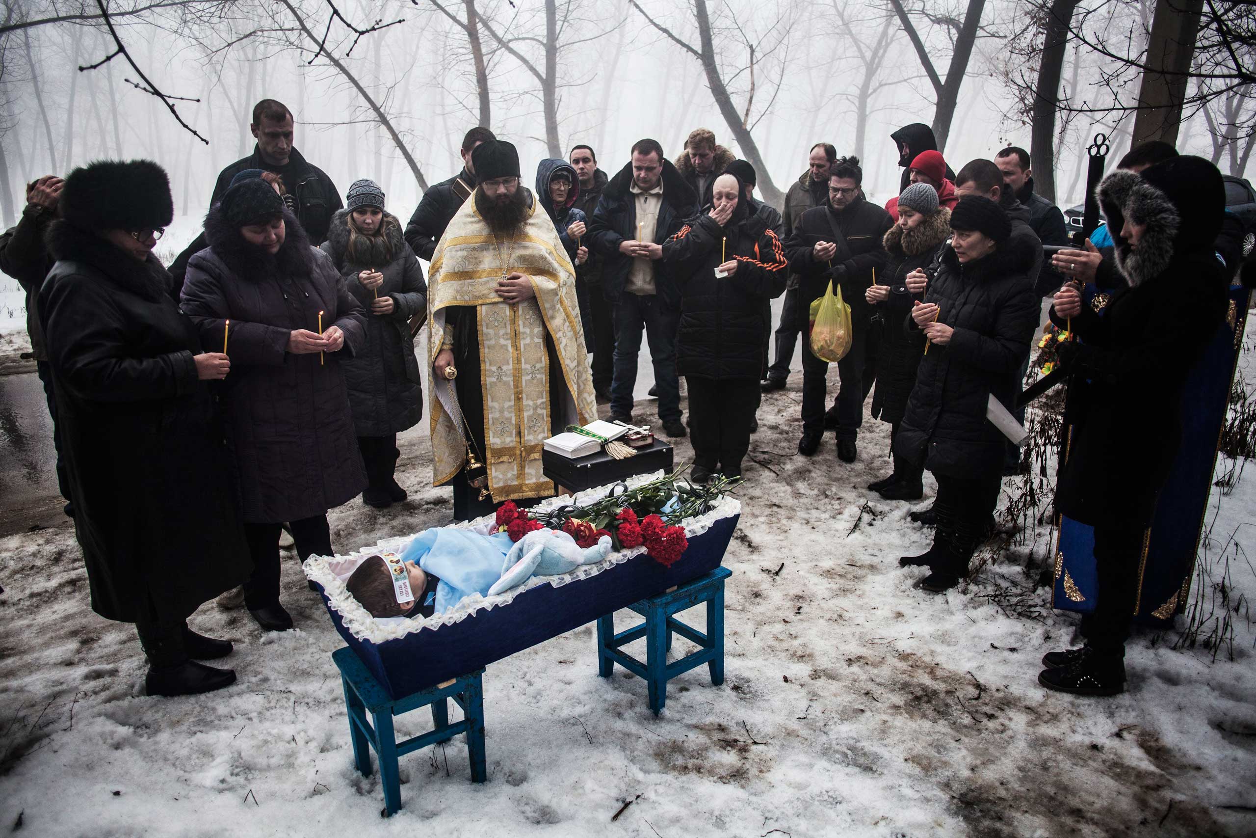 Jan. 20, 2015. Mourners gather around a coffin bearing Artiam, 4, who was killed in a Ukrainian army artillery strike, during his funeral in Kuivisevsky district on the outskirts of Donetsk, eastern Ukraine. At least three civilians were killed in shelling as fighting continued between government and rebel forces in the separatist-held city of Donetsk.