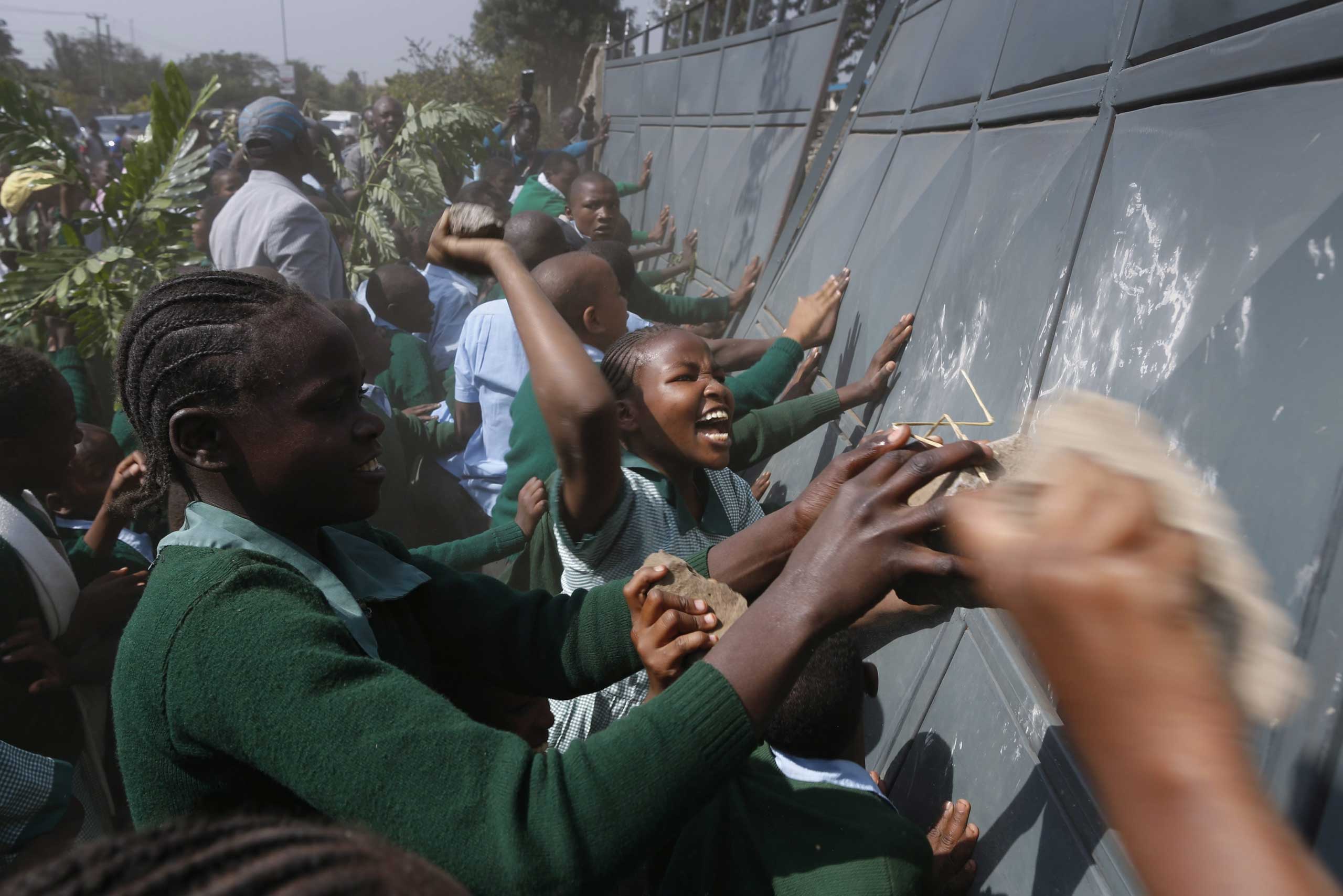 Jan. 19, 2015. School children push the fence to enter the school playground during a protest against alleged land grabbing at Langata Road Primary School in Nairobi, Kenya. At least 5 pupils have been rushed to the hospital after police fired teargas canisters at them and activists.