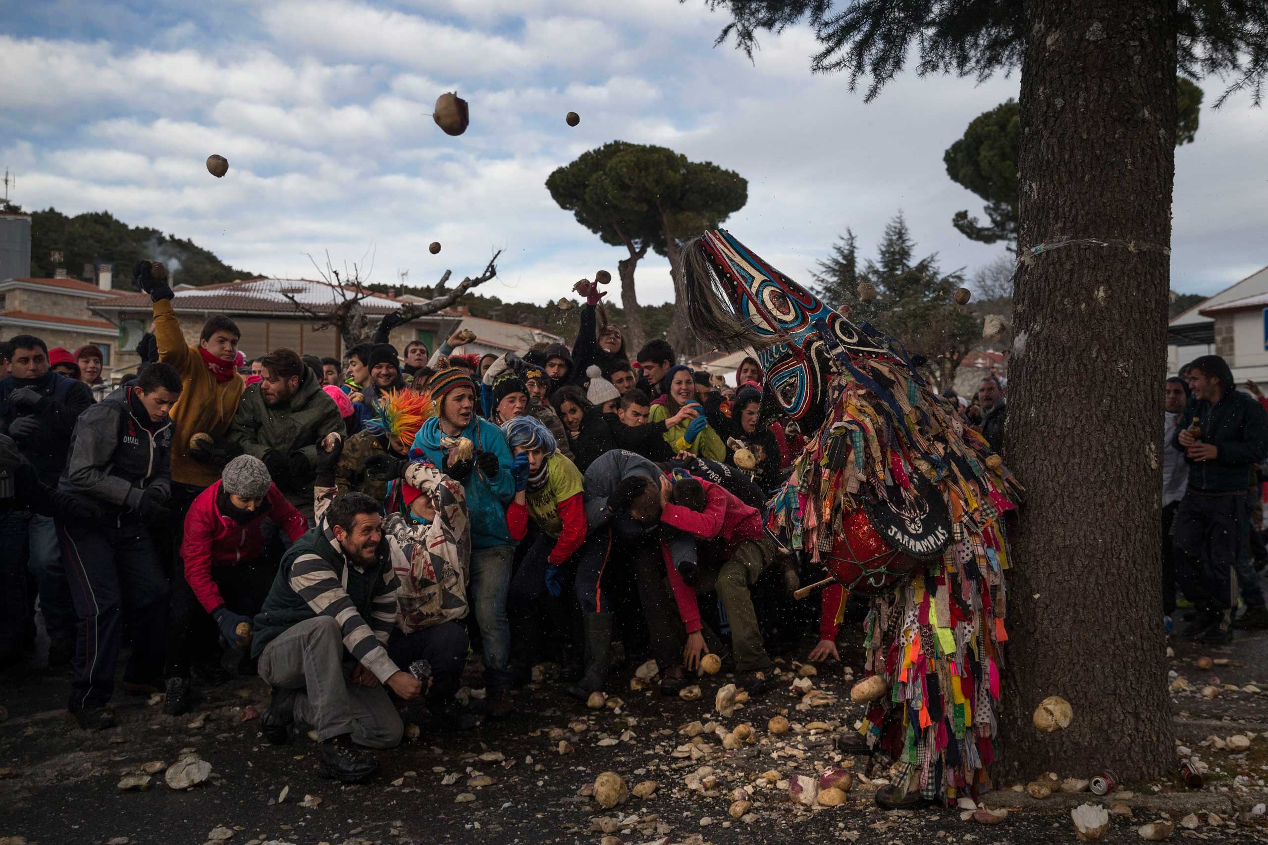 Jan. 19, 2015. People throw turnips at the Jarramplas as he makes his way through the streets beating his drum during the Jarramplas Festival in Spain. Jarramplas is a character that wears a costume made from colorful strips of fabric, and a devil-like mask and beats a drum through the streets of Piornal while residents throw turnips as a punishment for stealing cattle.
