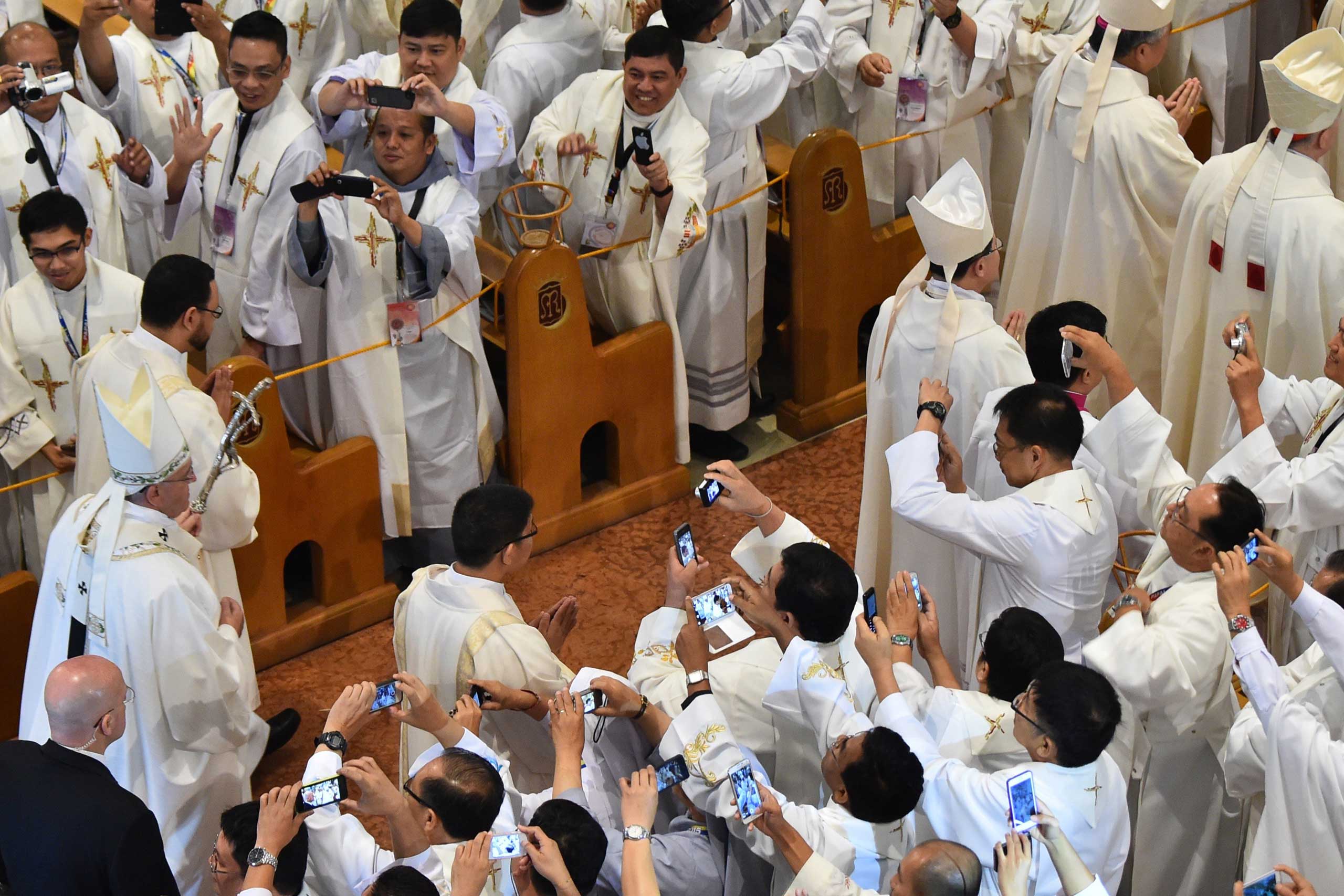 Jan. 16, 2015. Priests take pictures of Pope Francis as he arrives to lead a mass in Manila during his  five-day visit to the Philippines.