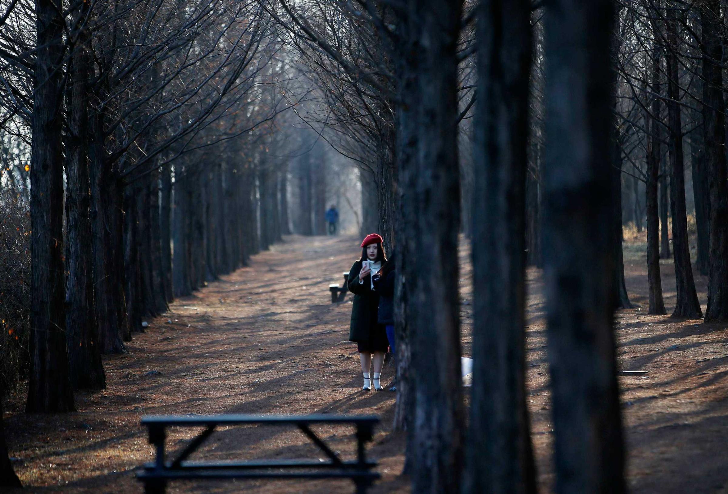 A woman takes a "selfie" on a cold winter day at a park in Seoul