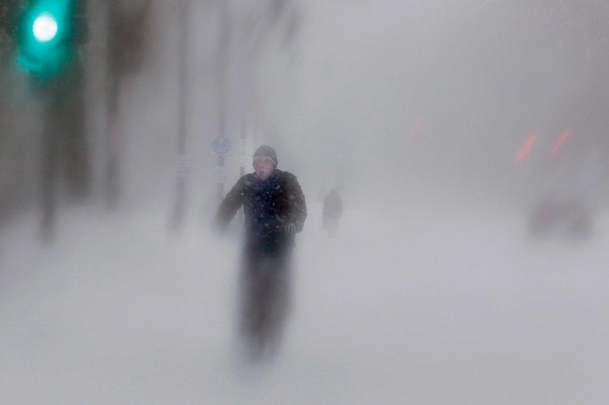 A man rides his bike up Beacon Street during a blizzard in Boston