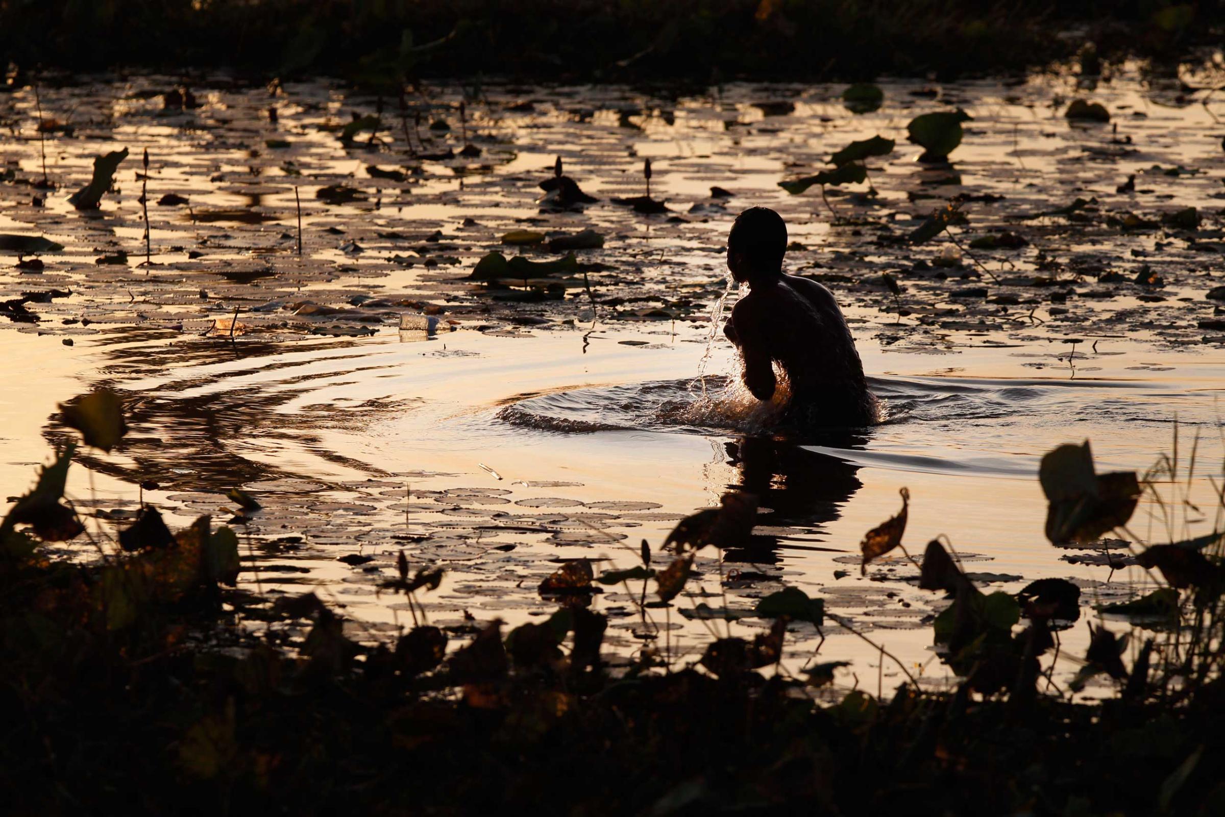 Jan. 11, 2015. A man takes his evening bath in a pond at O-Treng village at the outskirt of Phnom Penh.