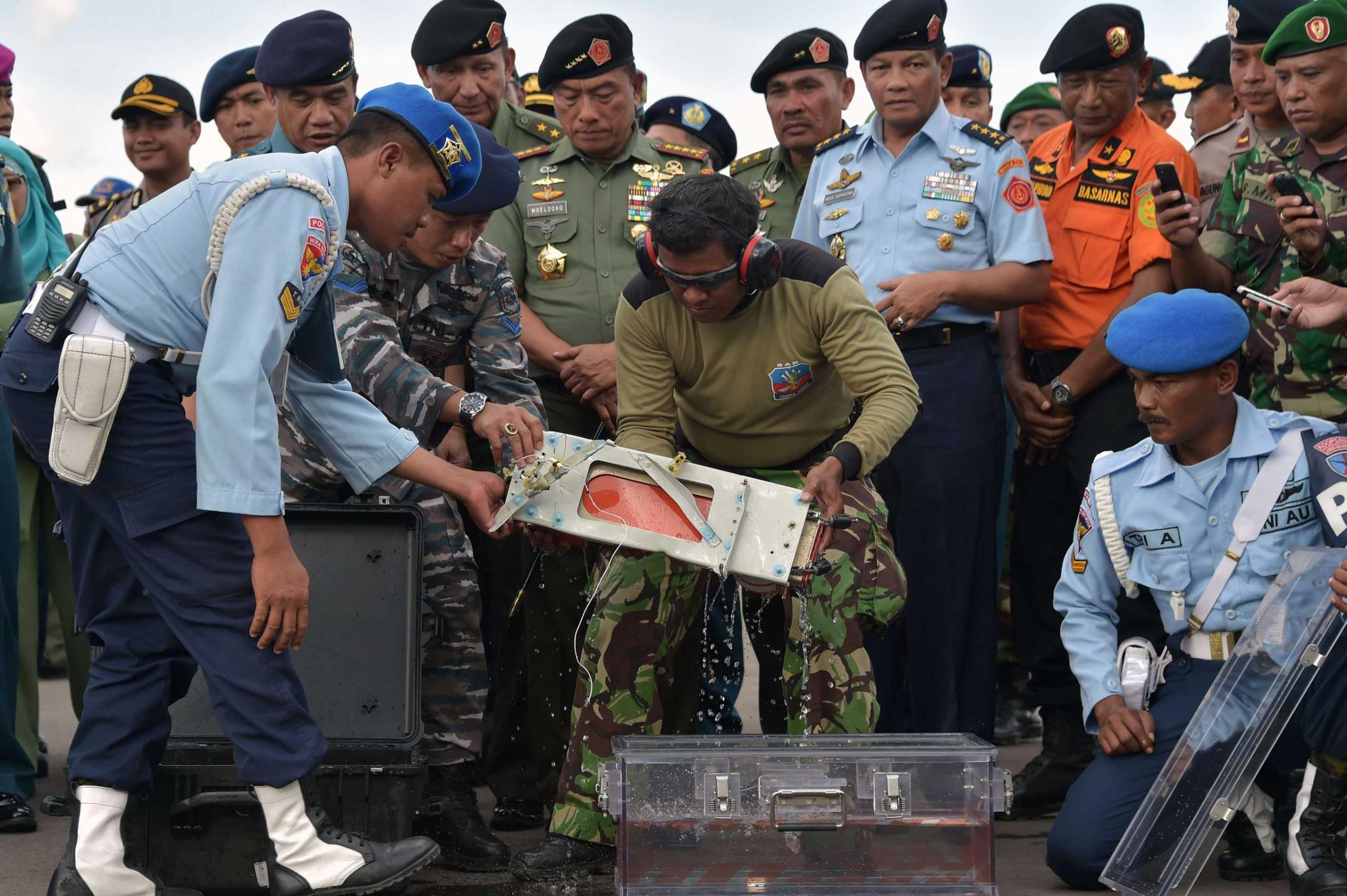 Jan. 12, 2015. Indonesian officers move the flight data recorder of the AirAsia flight QZ8501 that went down with 162 passengers into a suitable protective transportation case in the town of Pangkalan Bun in Indonesia after it was retrieved from the Java Sea.