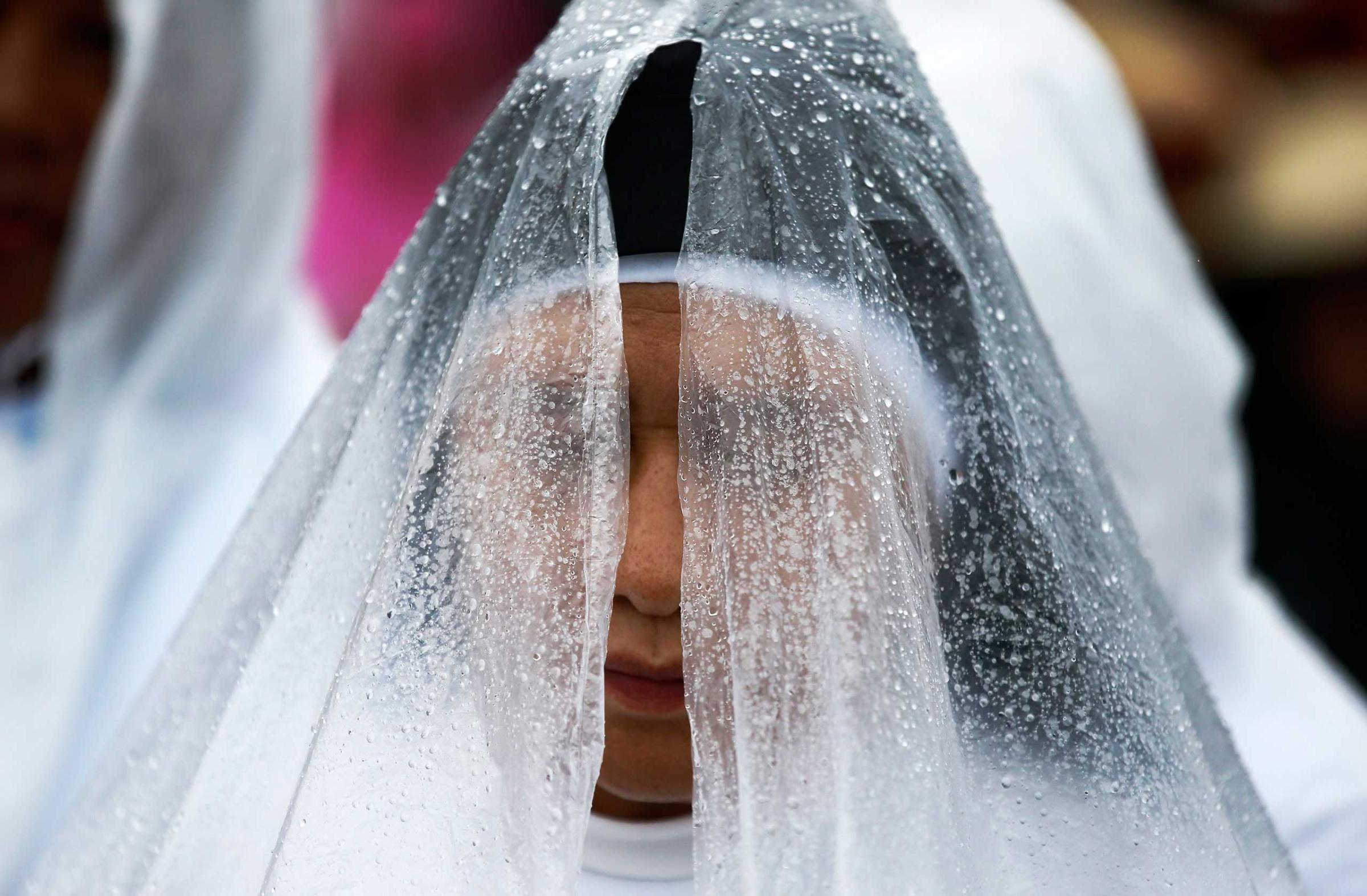 A Filipino nun prays during a downpour prior to Pope Francis mass in Manila, Jan. 18, 2015.