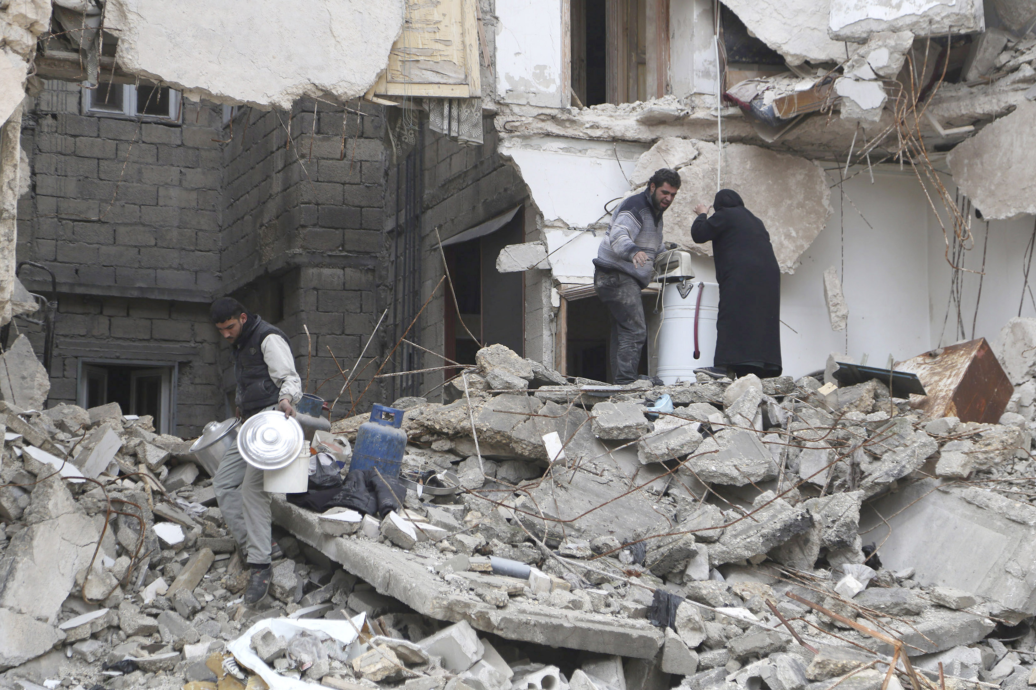 Residents look for belongings amid debris of a collapsed building in Aleppo December 31, 2014. (Hamid Khatib—Reuters)