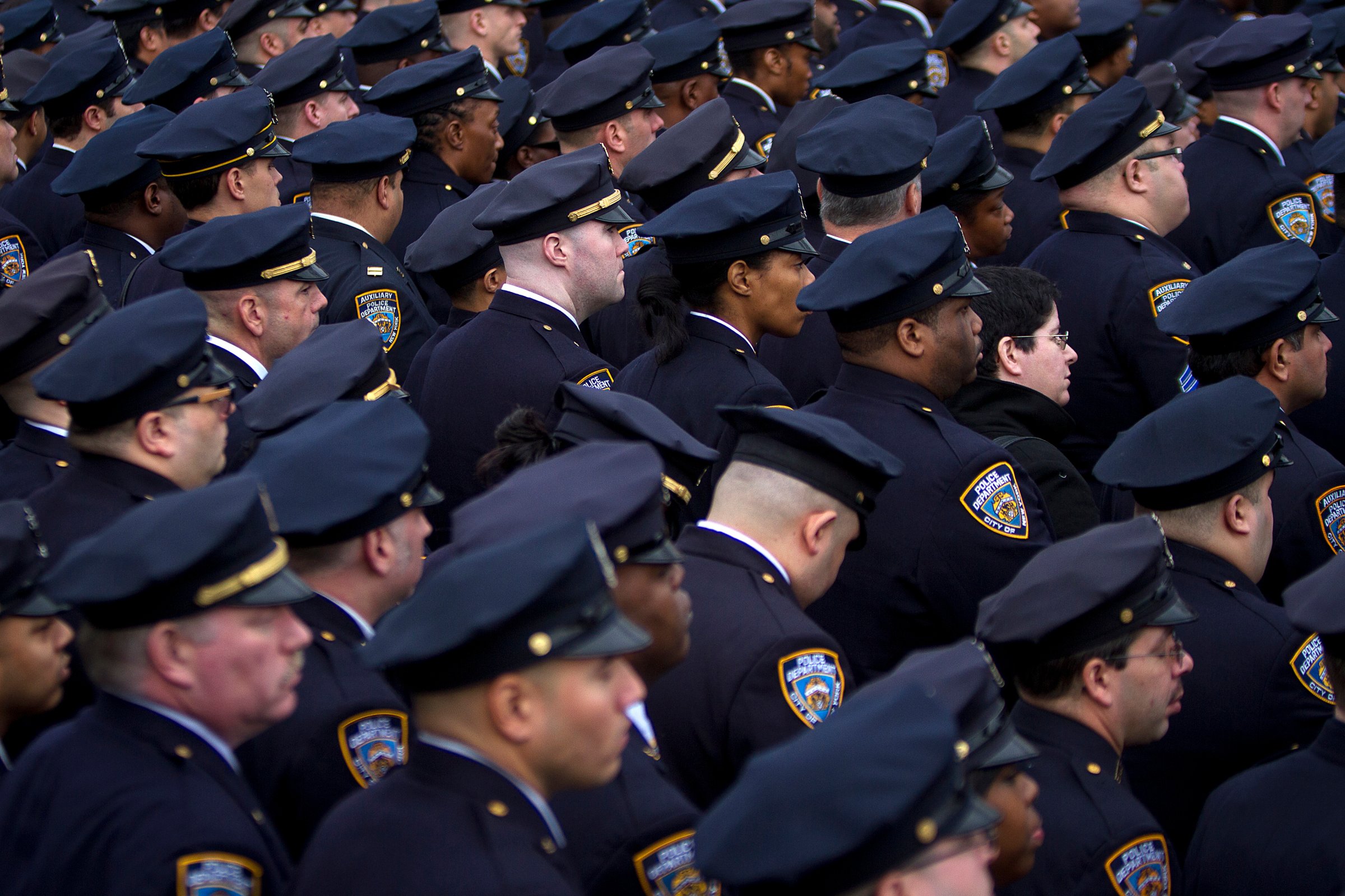 Police officers from the 84th Precinct listen during the funeral for slain New York Police Department officer Liu in the Brooklyn borough of New York