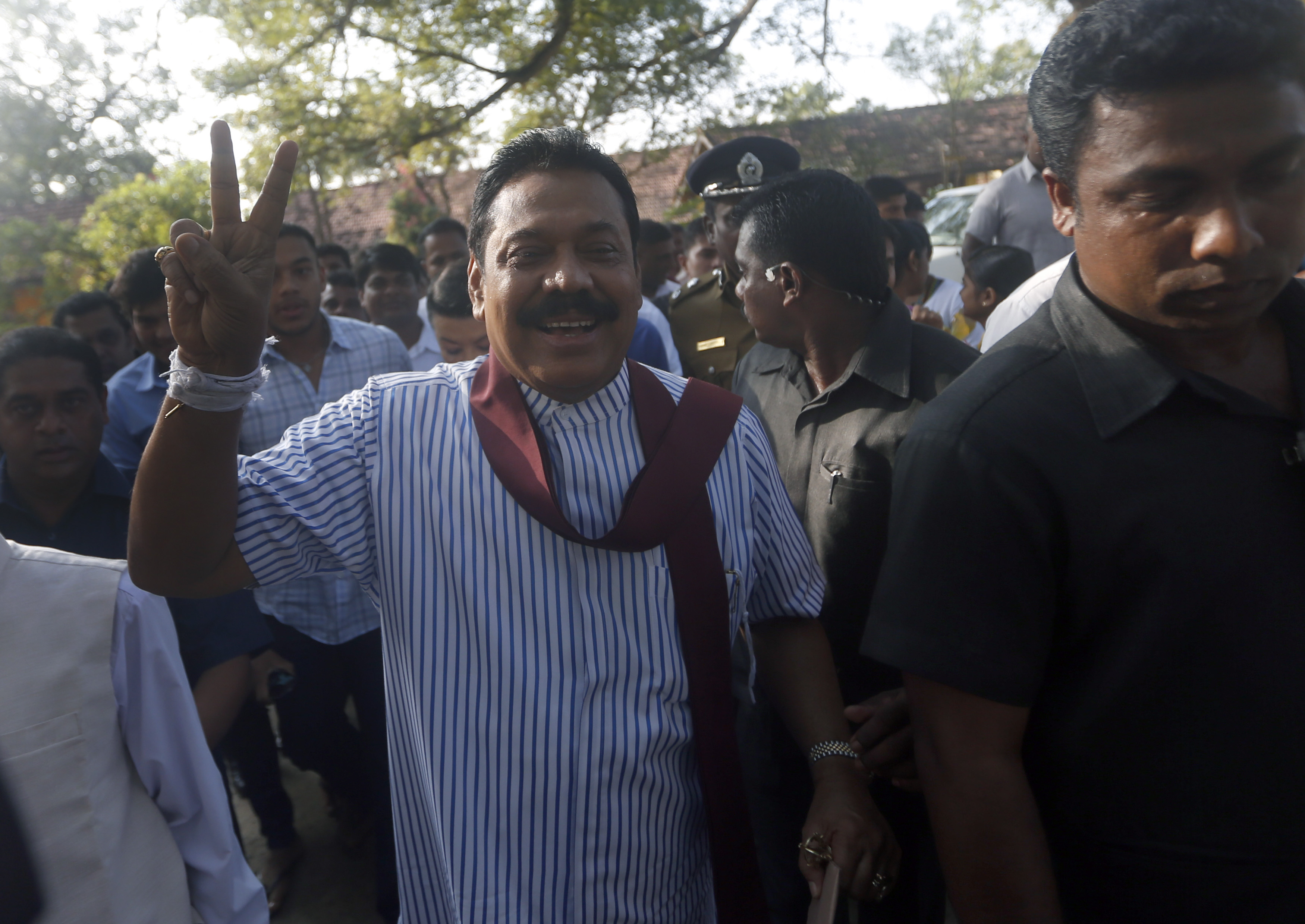 Sri Lanka's President Mahinda Rajapaksa gestures to the media after casting his vote for the presidential election, in Medamulana