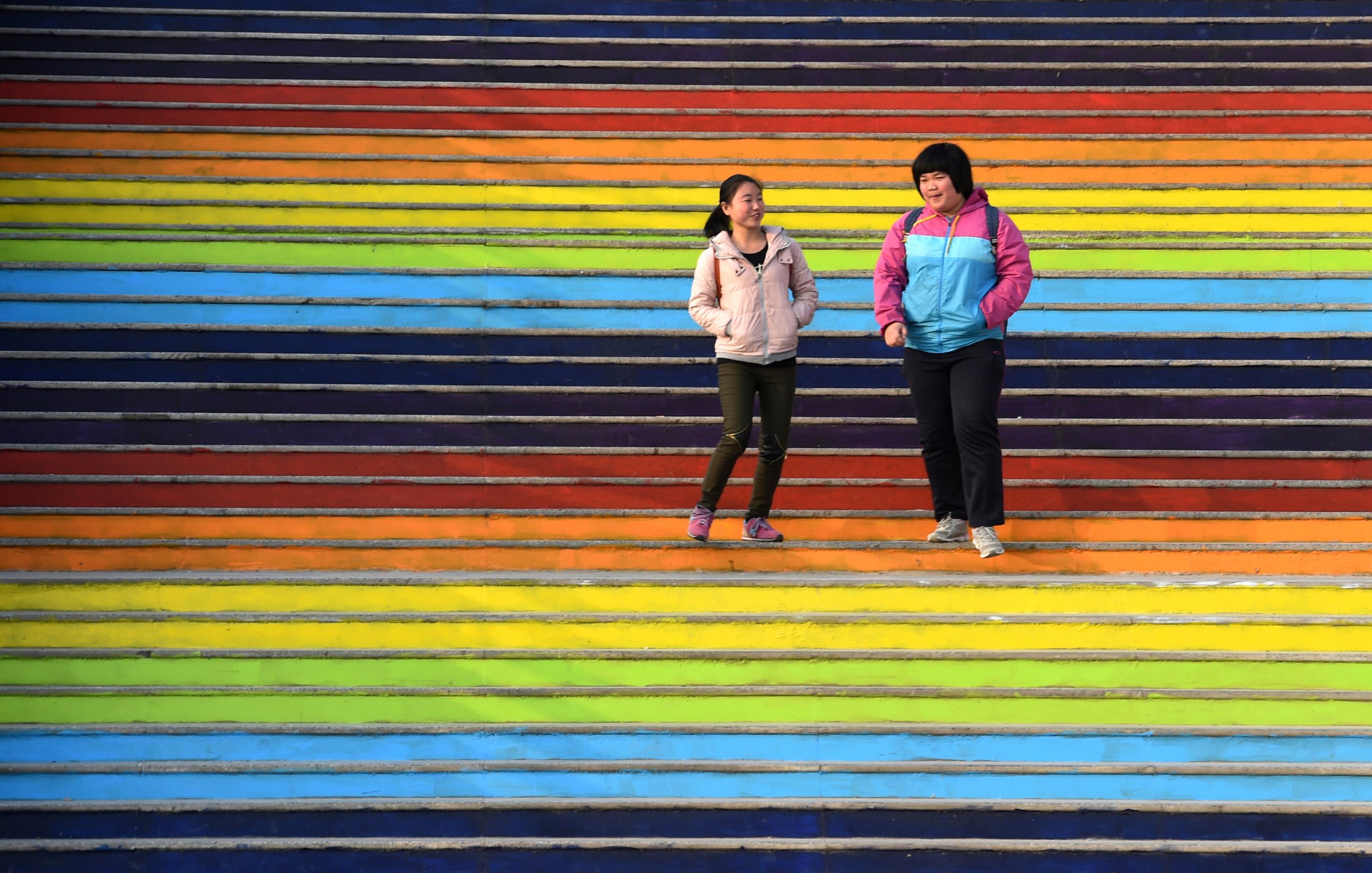 Students walk down a flight of stairs outside a dining hall at the campus of a university in Zhengzhou
