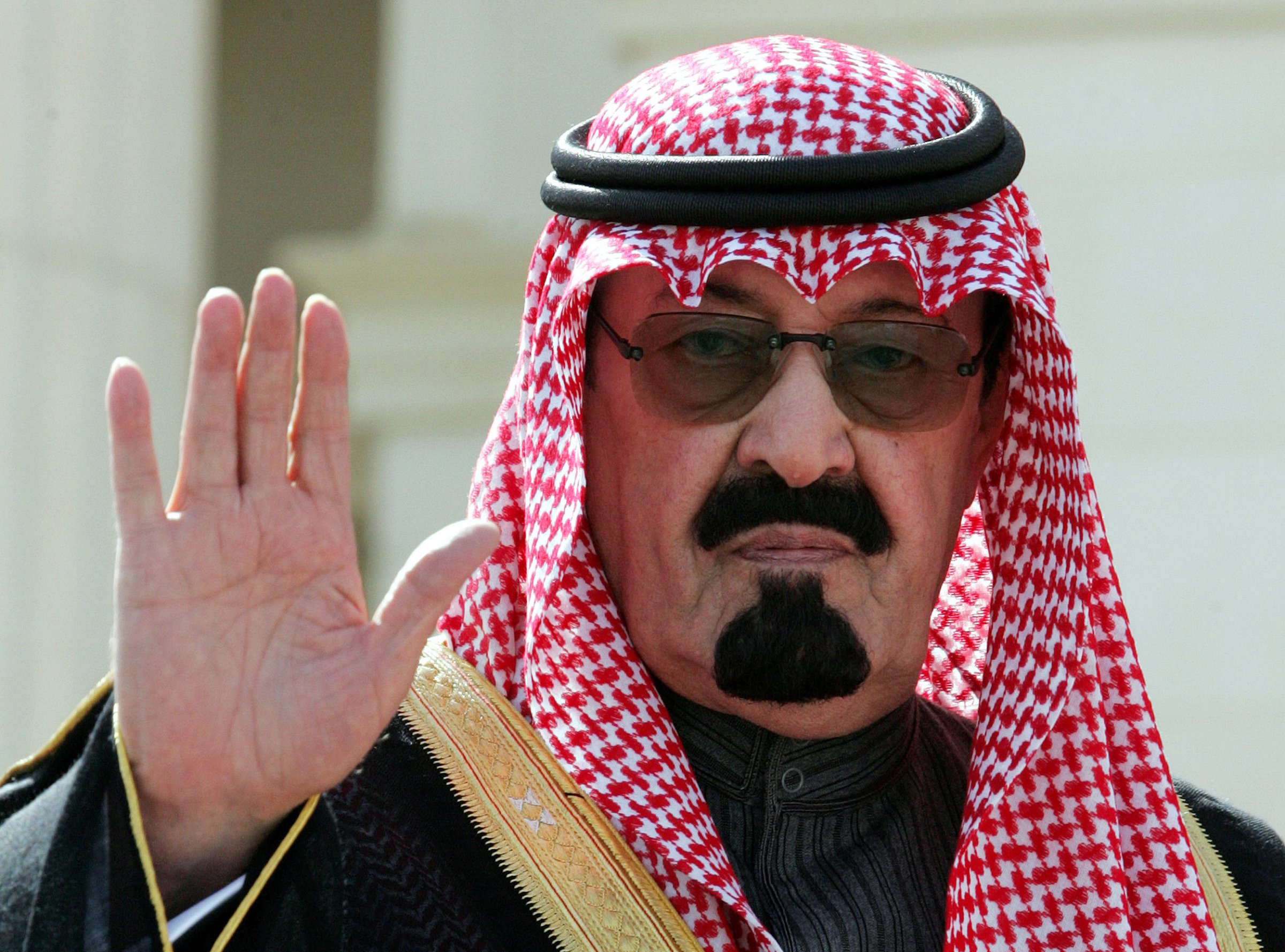 King Abdullah waves as he arrives to open a conference in Riyadh.
