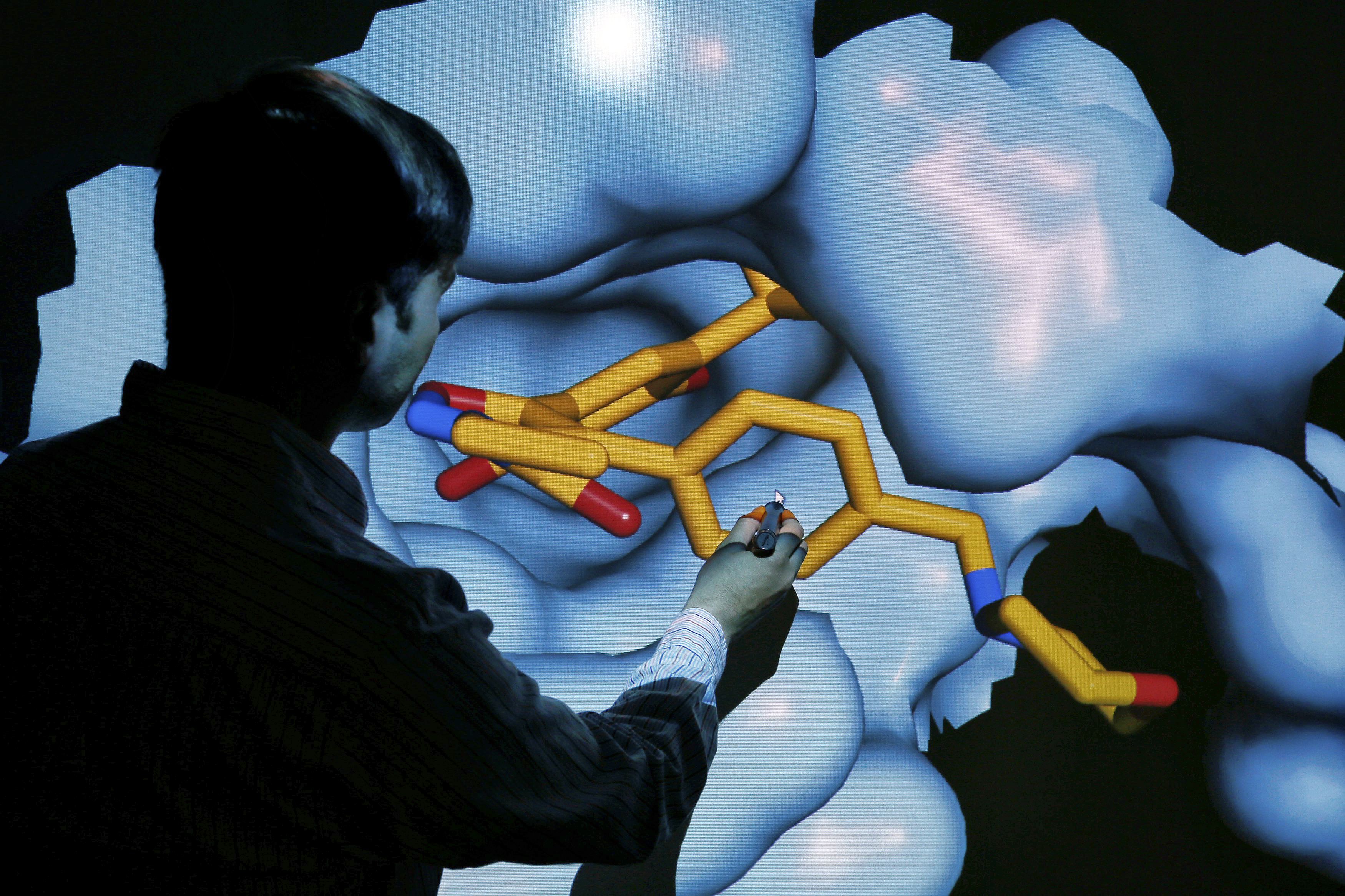 Scientist Brown moves a 3D model of a HSP90 protein on a screen at the Institute of Cancer Research in Sutton