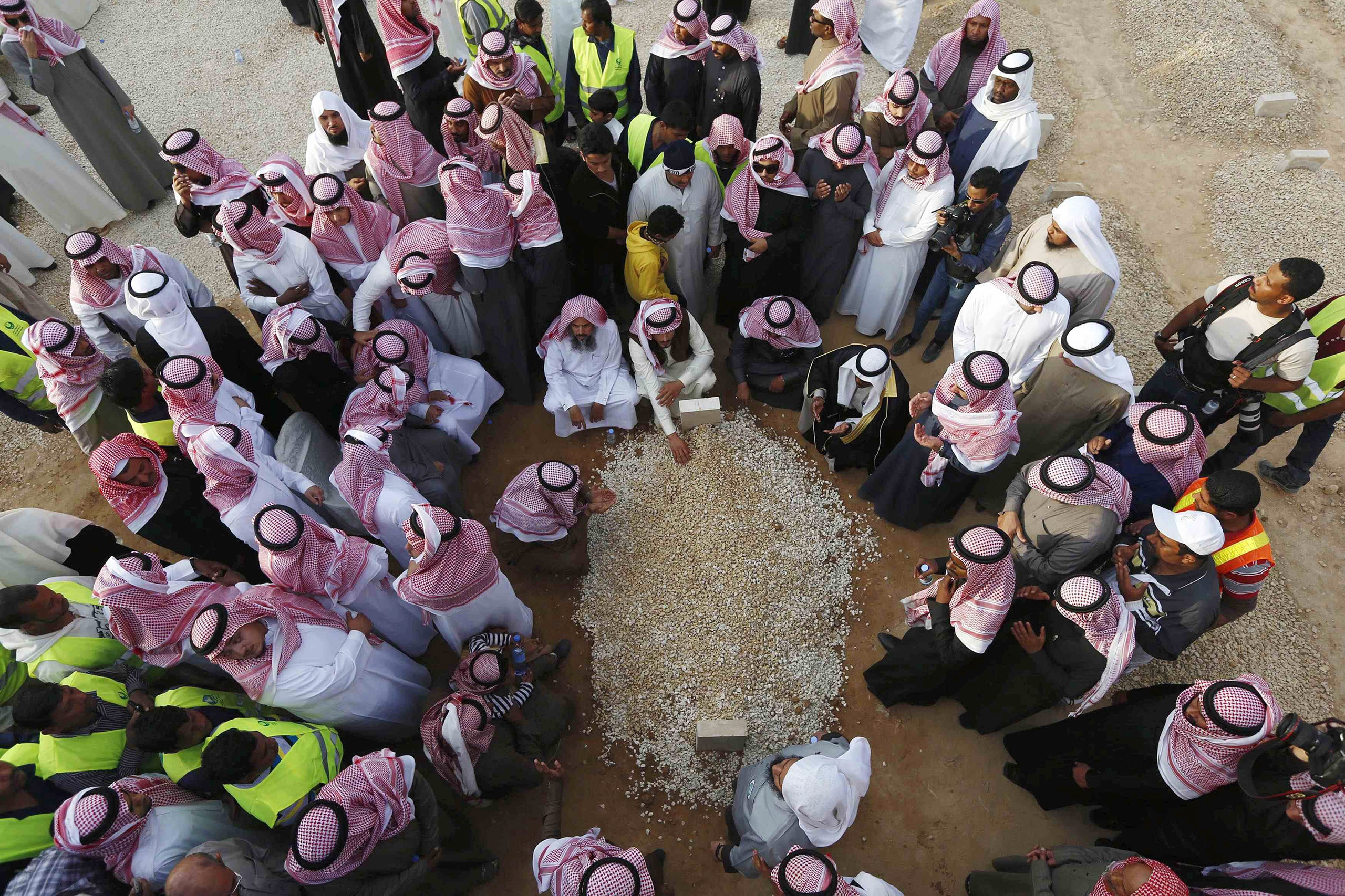 Mourners gather around the grave of Saudi King Abdullah following his burial in Riyadh