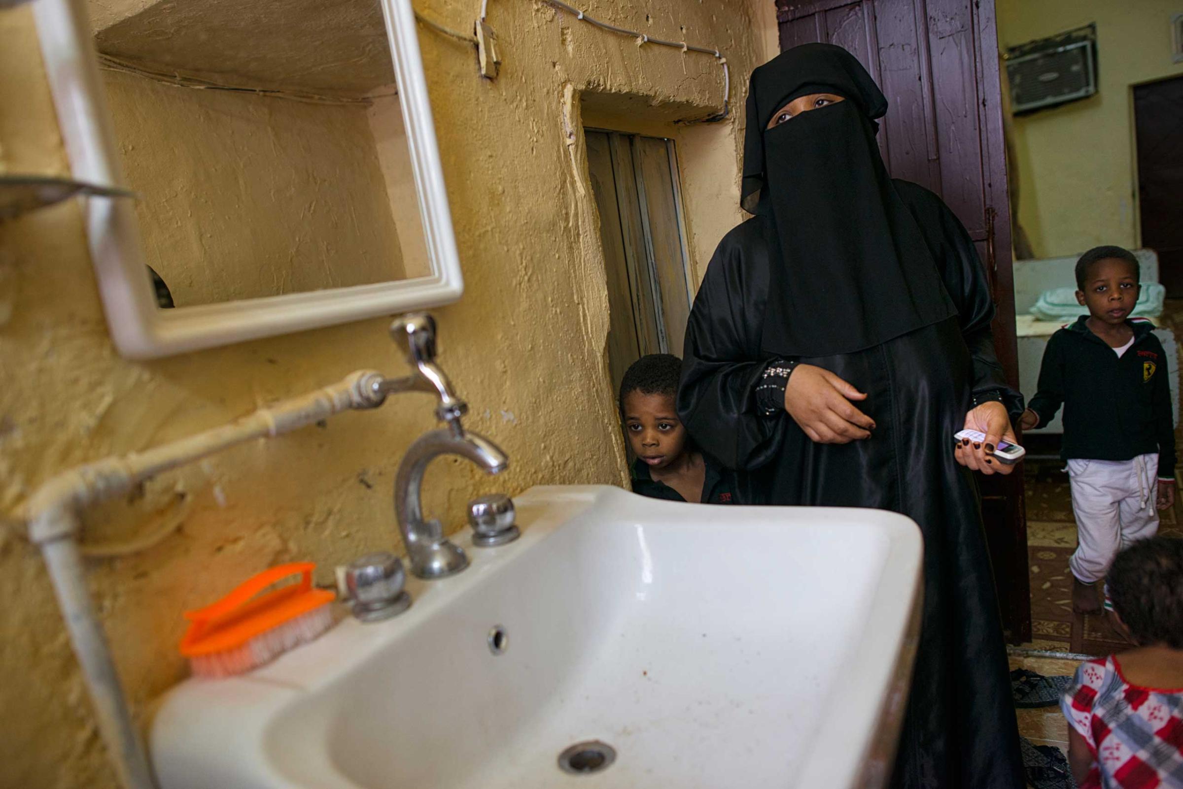 Matara stands with her two boys next to a sink without water, where she lives in squalor in a neighborhood in South Riyadh, Saudi Arabia,  March 1, 2013.   Like many families across Saudi Arabia who are barely scraping above the poverty line each month, this family relies on the hope of the charity of others to survive. (Credit: Lynsey Addario/ VII)