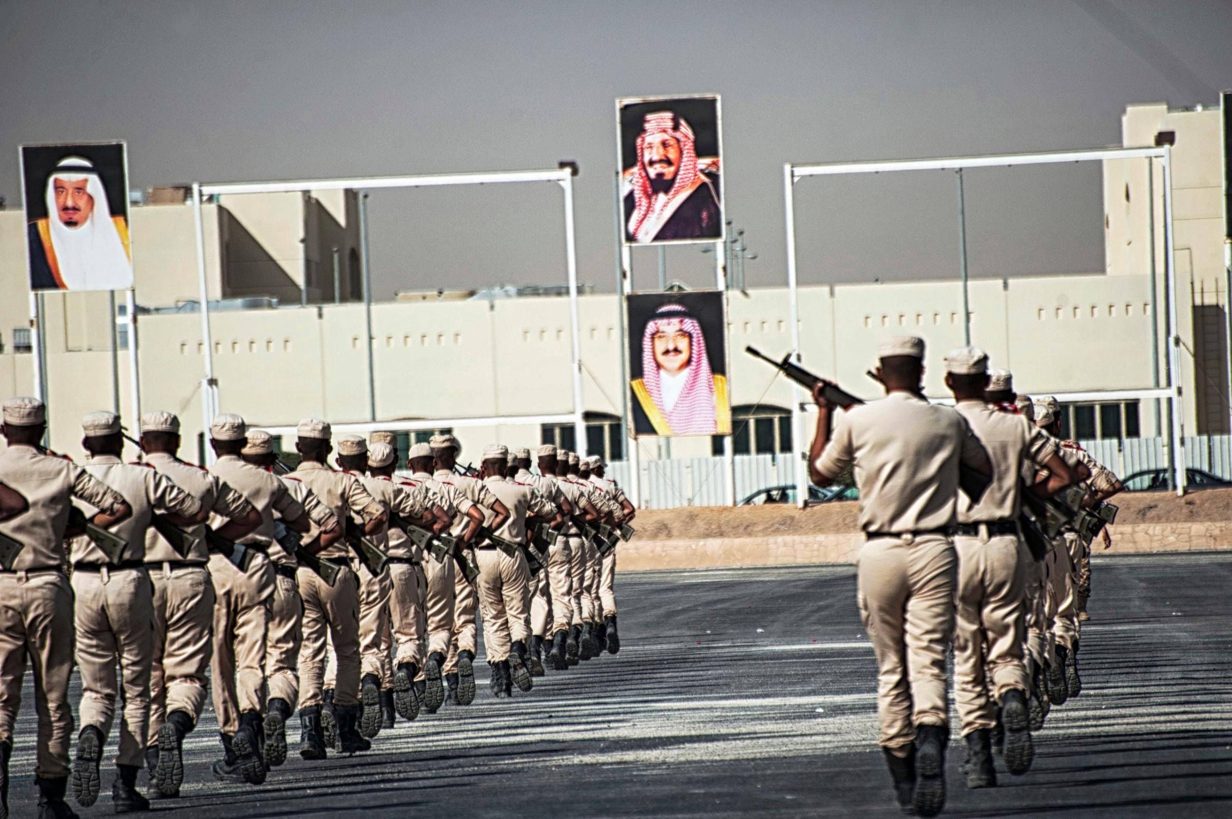 Troops with the Saudi Special Security Forces perform a show of force below images of the Royal family, from left: King Salman bin AbdulAziz, King AbdulAziz, Prince Mohammed bin Nayef, at the Counter-Terrorism Training School camp under the Ministry of Interior in Riyadh, Saudi Arabia, March 5, 2013.  The Saudi government has been fighting terrorism within the Kingdom for decades, and has roughly 3,000 SEF in Riyadh, alone.  Despite a fraugh relationship with the United States in the past, Saudi Arabia and the U.S. have routinely shared security information in order to prevent and fight terrorism.  With the recent death of HRH King Abdullah, the international community is looking to the newly appointed HRH King Salman to see how he develop the Kingdom's relationship with the West.  (Credit: Lynsey Addario/ Getty Reportage)
