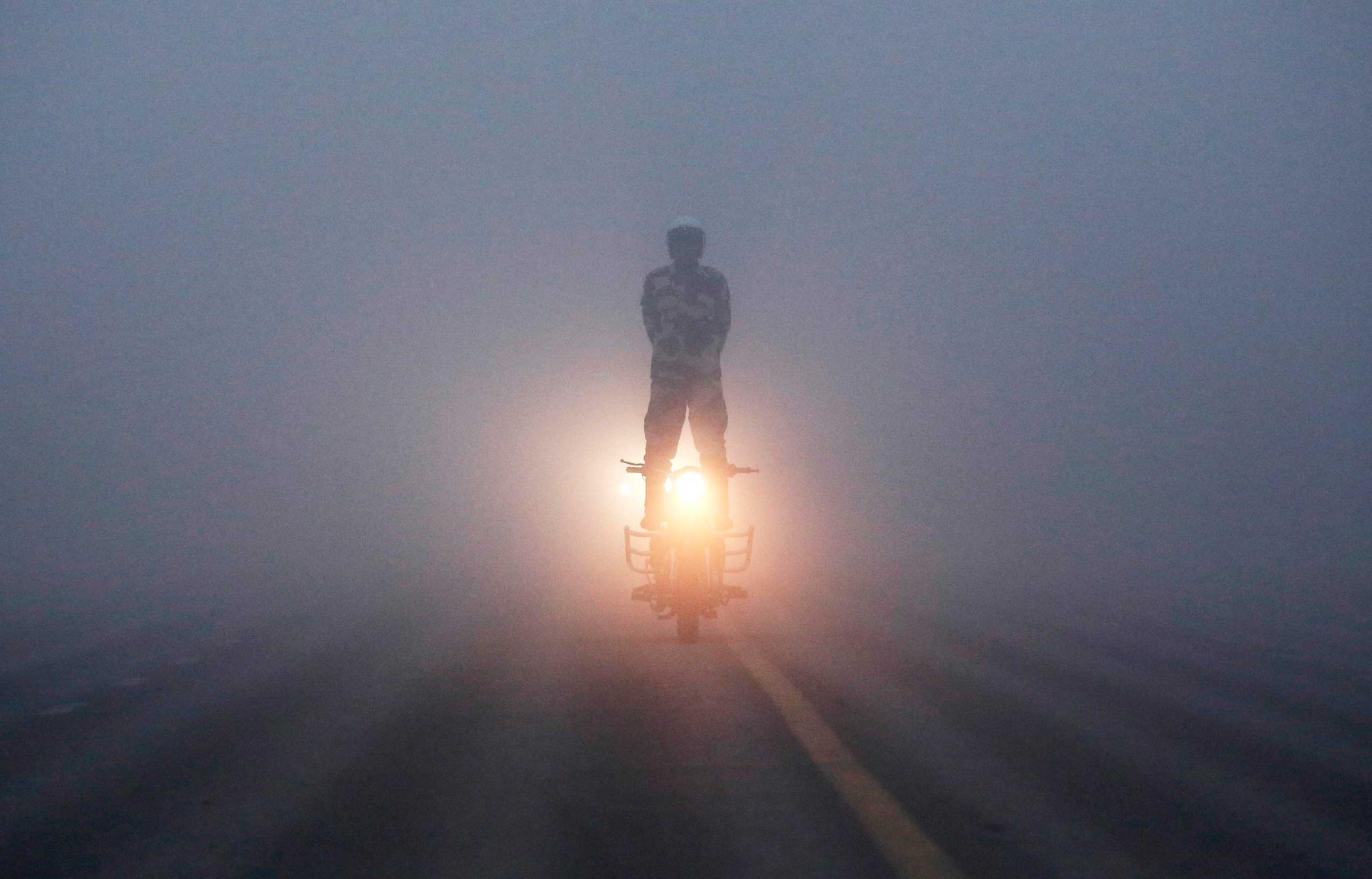 India's BSF "Daredevils" motorcycle rider performs during a rehearsal for the Republic Day parade on a foggy winter morning in New Delhi