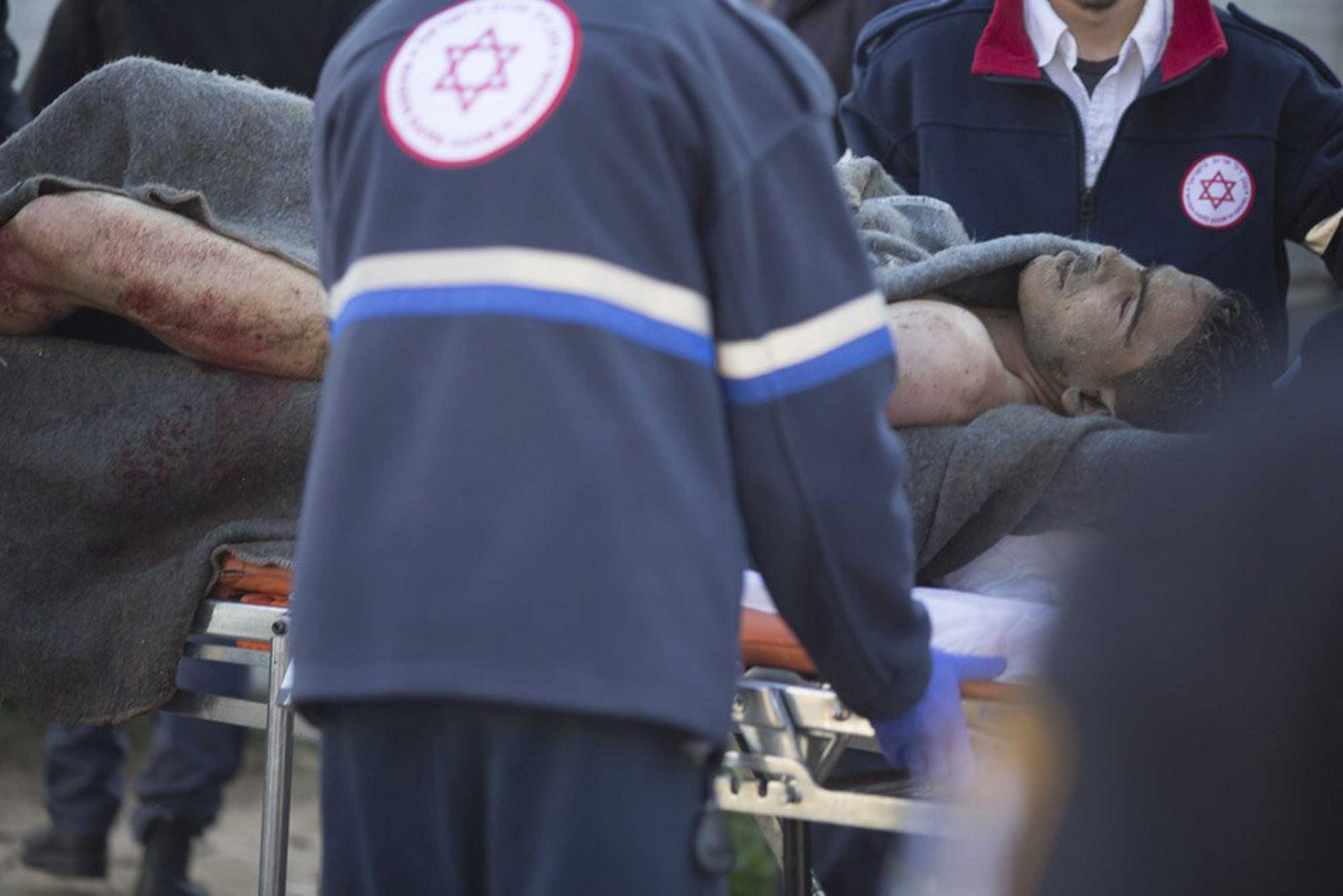 Israeli police carry the injured suspect on a stretcher as they attend the scene of a stabbing attack on Jan. 21, 2015 in Tel Aviv.