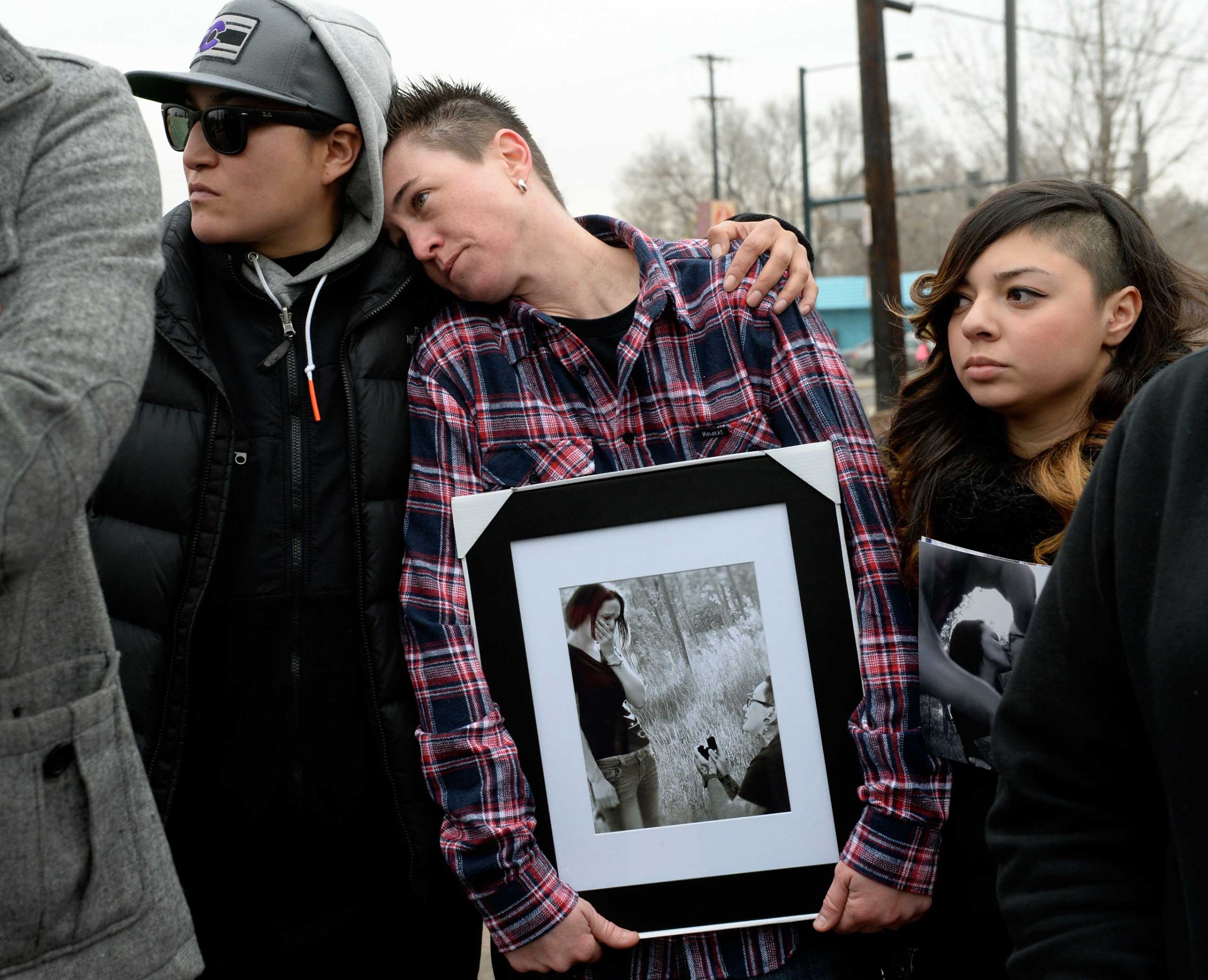 Cheyenne Poorbear, Samantha Getman and Victoria Quintana display photographs of Vanessa Collier and her partner, Christina Higley, during a rally outside New Hope Ministries in Lakewood, Colo. Jan. 13, 2015.