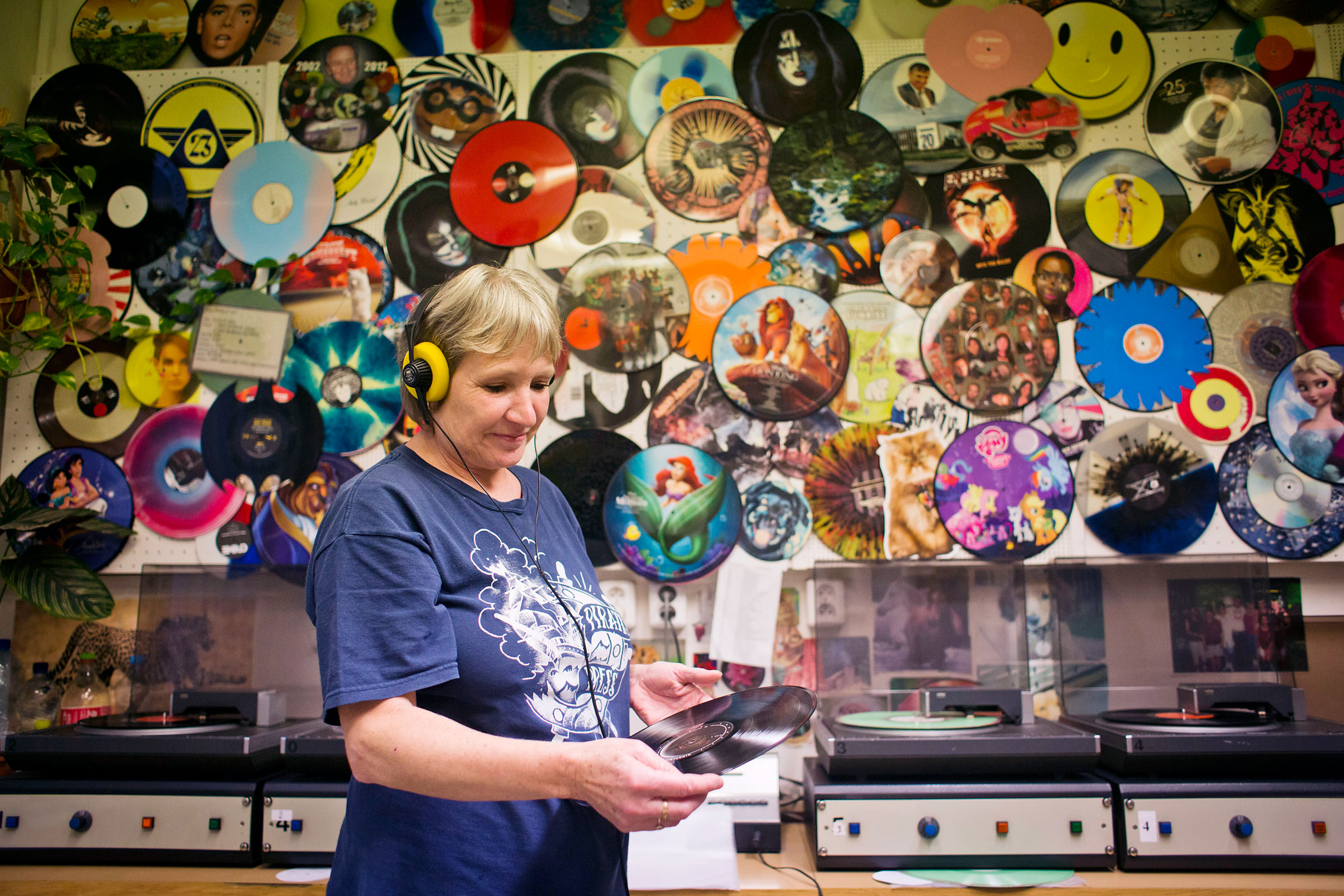 A worker listens through headphones and checks the sound quality of 12" inch vinyl records before they are dispatched, after being manufactured by GZ Media a.s. at their plant in Lodenice, Czech Republic, on Nov. 25, 2014. (Martin Divisek—Bloomberg/Getty Images)
