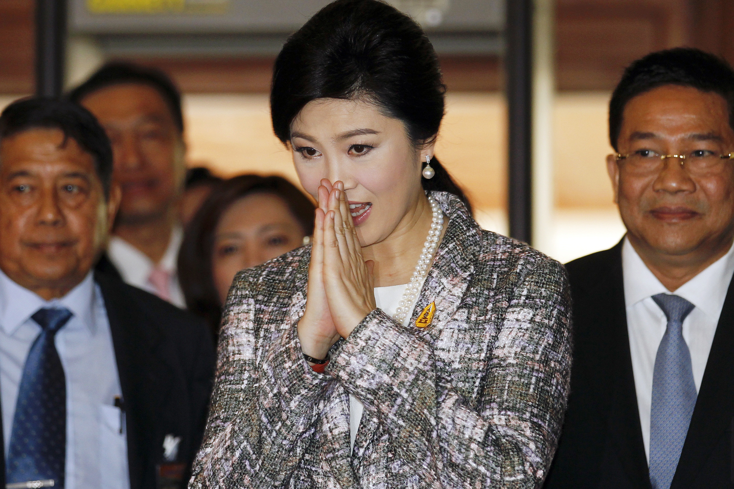 Ousted former Prime Minister Yingluck Shinawatra greets in a traditional way as she arrives at Parliament before the National Legislative Assembly meeting in Bangkok