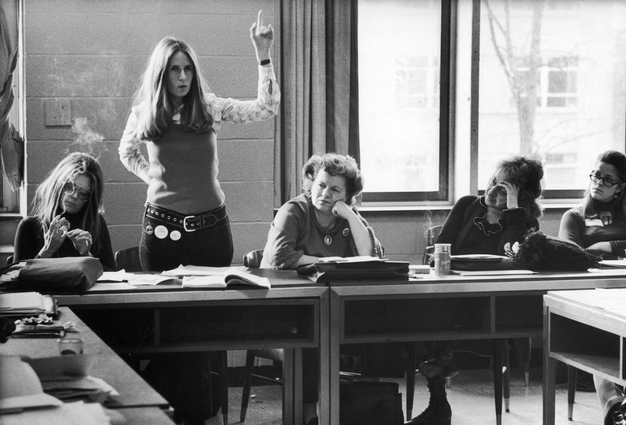 New York lawyer Brenda Feigen Fasteau, arm raised, argues about candidate support at a Washington meeting of the Caucus's National Policy Council. Some fellow members, left to right are: Ms. editor Gloria Steinem, National Organization for Women (NOW) president Wilma Scott Heide and author Betty Friedan.