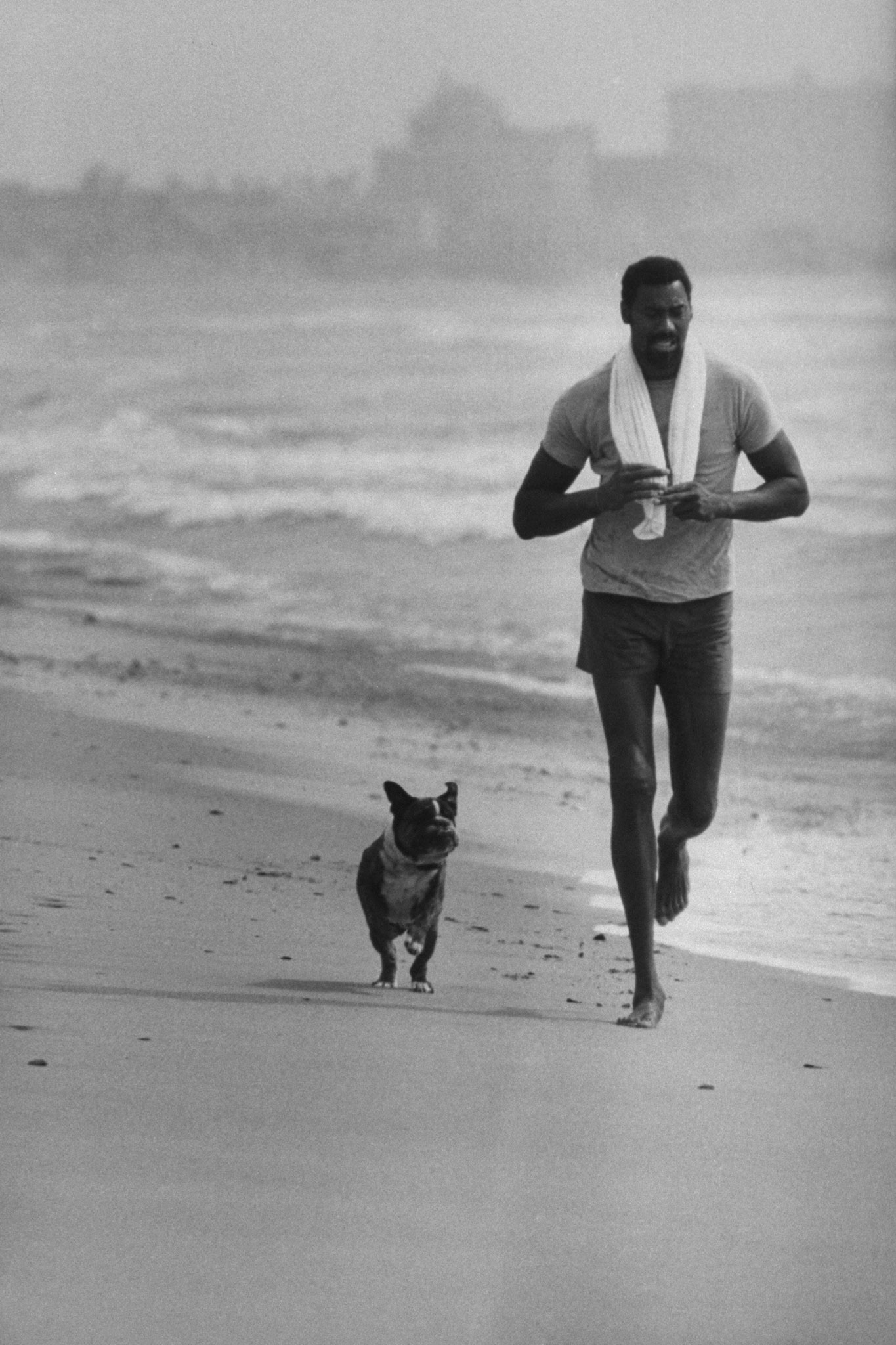 Wilt Chamberlain jogging on a beach in California, 1970.