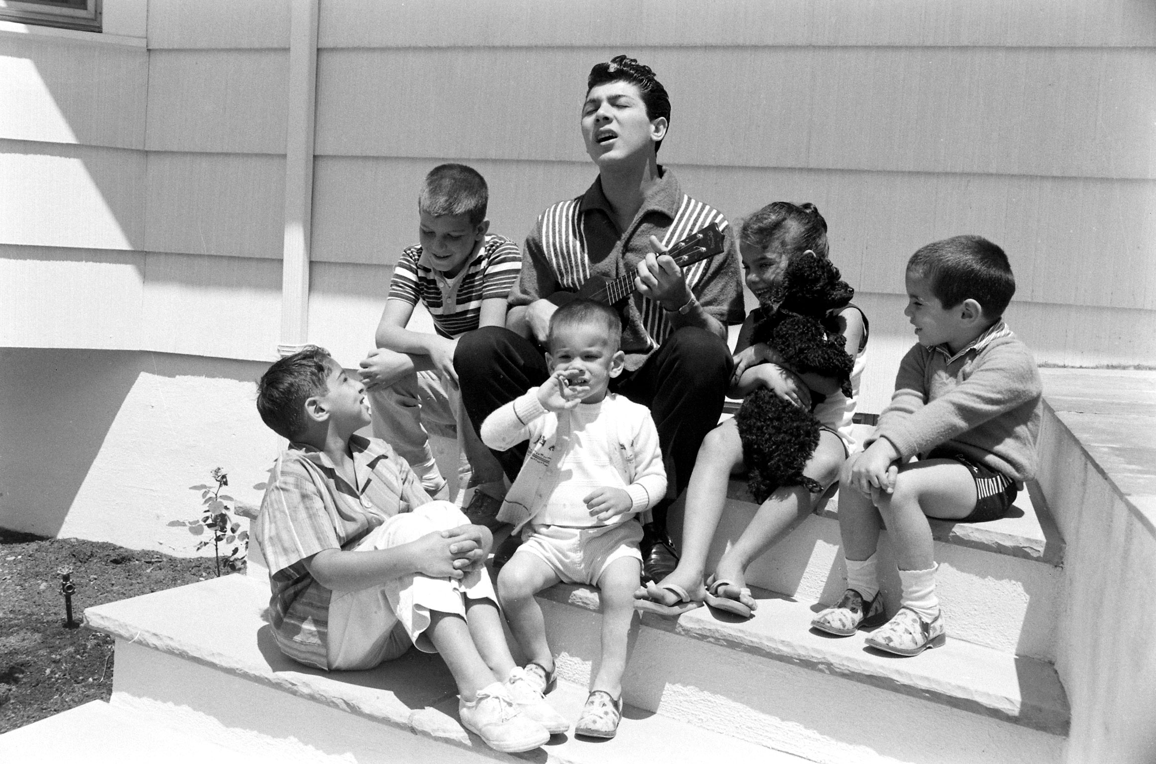 Paul Anka singing with children, 1960.