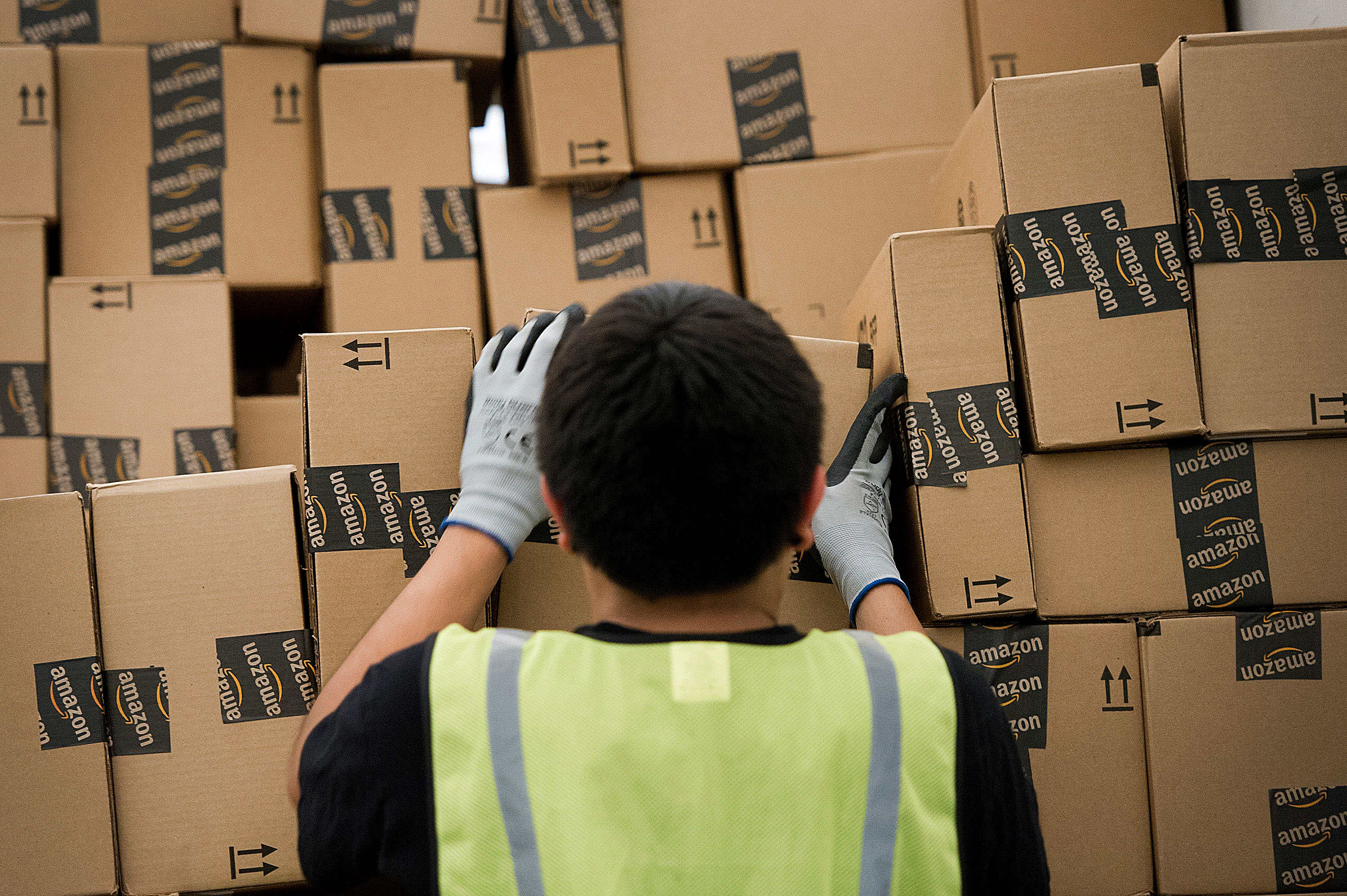 An employee loads a truck with boxes to be shipped at the Amazon.com Inc. distribution center. (Bloomberg/Getty Images)