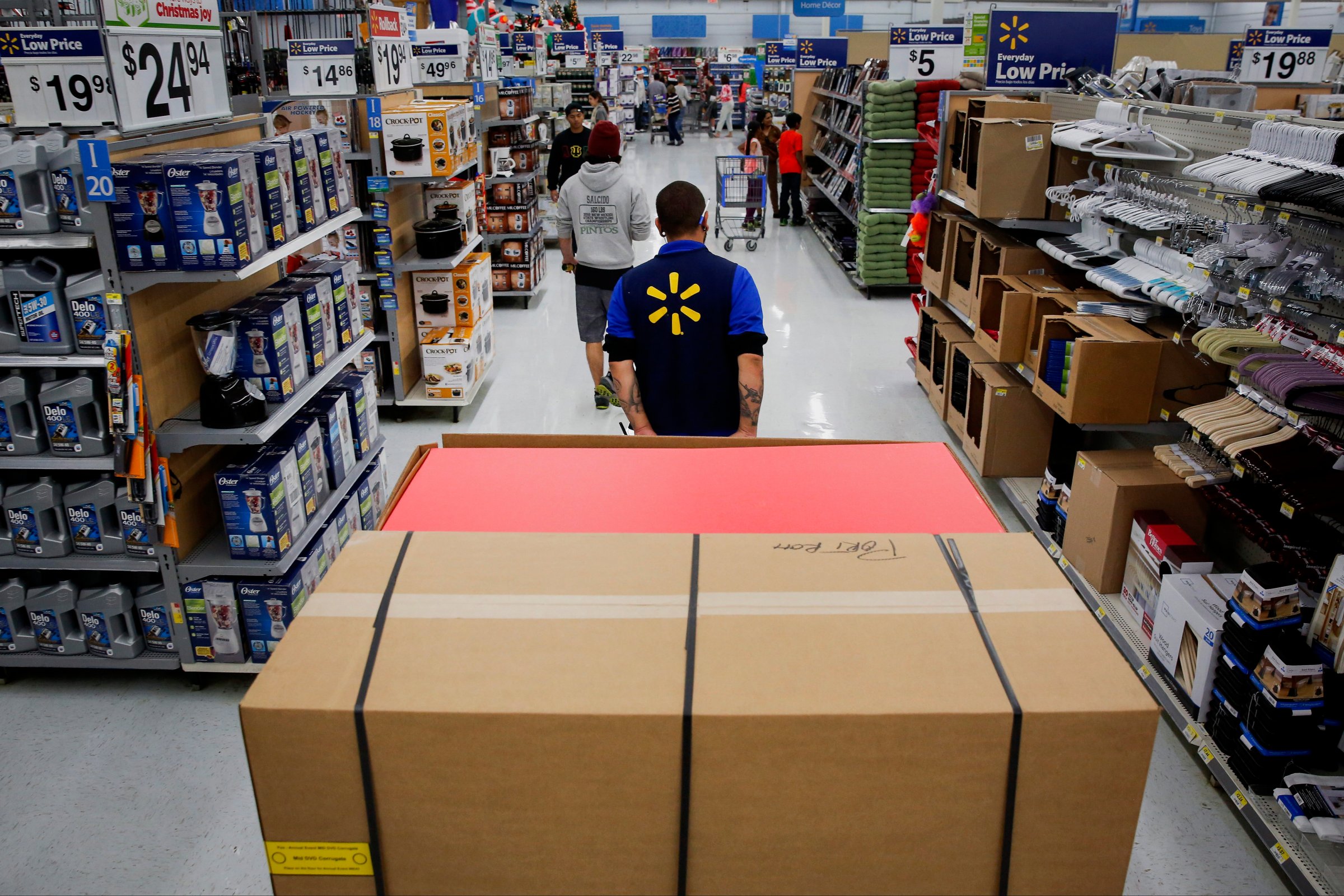 An employee pulls a forklift with display units for DVD movies at a Wal-Mart Stores Inc. location ahead of Black Friday in Los Angeles, Calif. on Nov. 24, 2014.