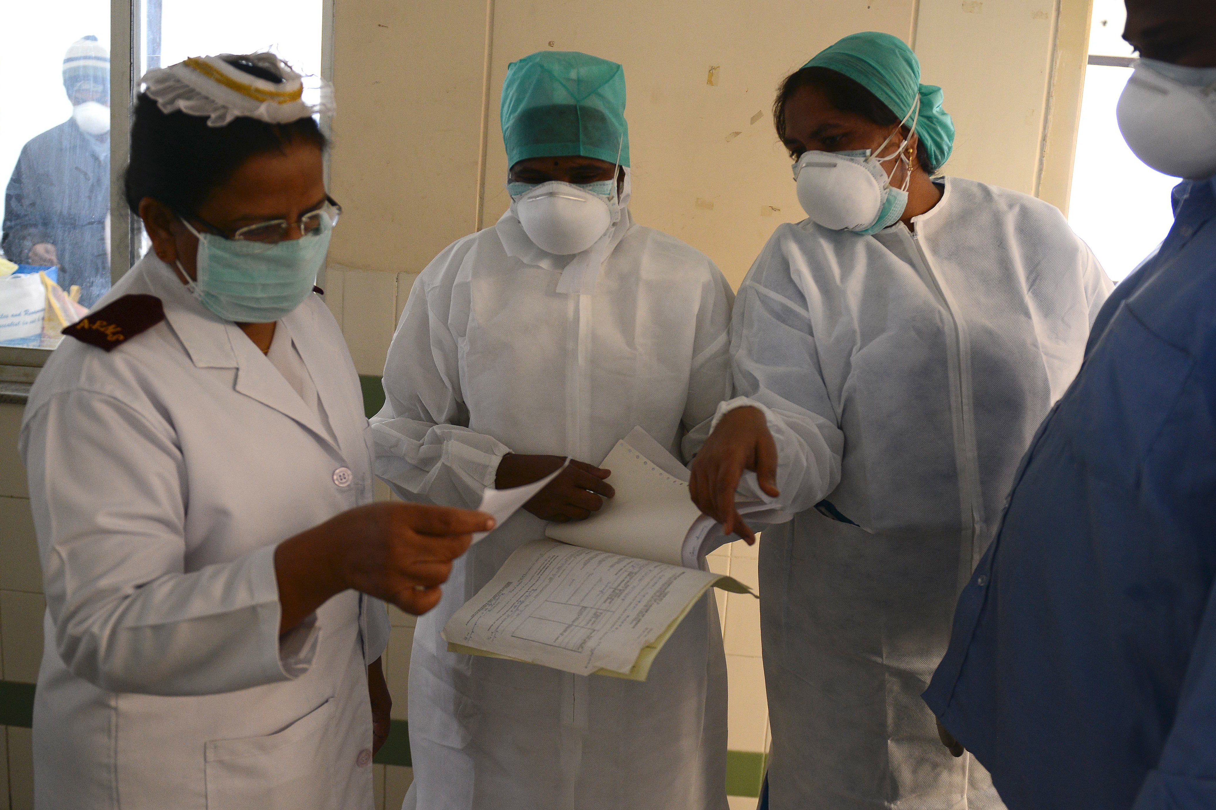 Indian health professionals inspect the case sheet of a swine flu patient at a ward at the Gandhi Hospital in Hyderabad on Jan. 21, 2015 (Noah Seelam—AFP/Getty Images)