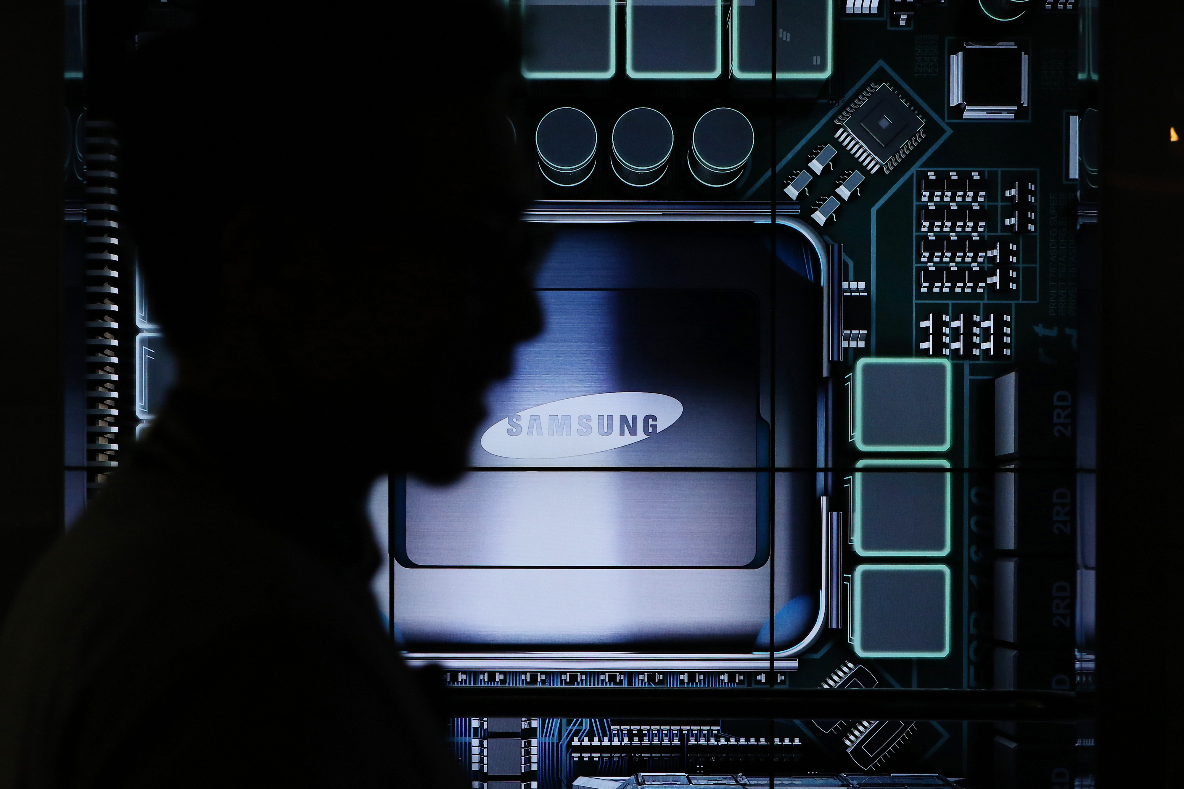 A visitor walks past the Samsung Electronics Co. logo displayed at the Semiconductor Rider experience at the company's d'light showroom in Seoul, South Korea, on Tuesday, Jan. 27, 2015. (SeongJoon Cho—Bloomberg via Getty Images)
