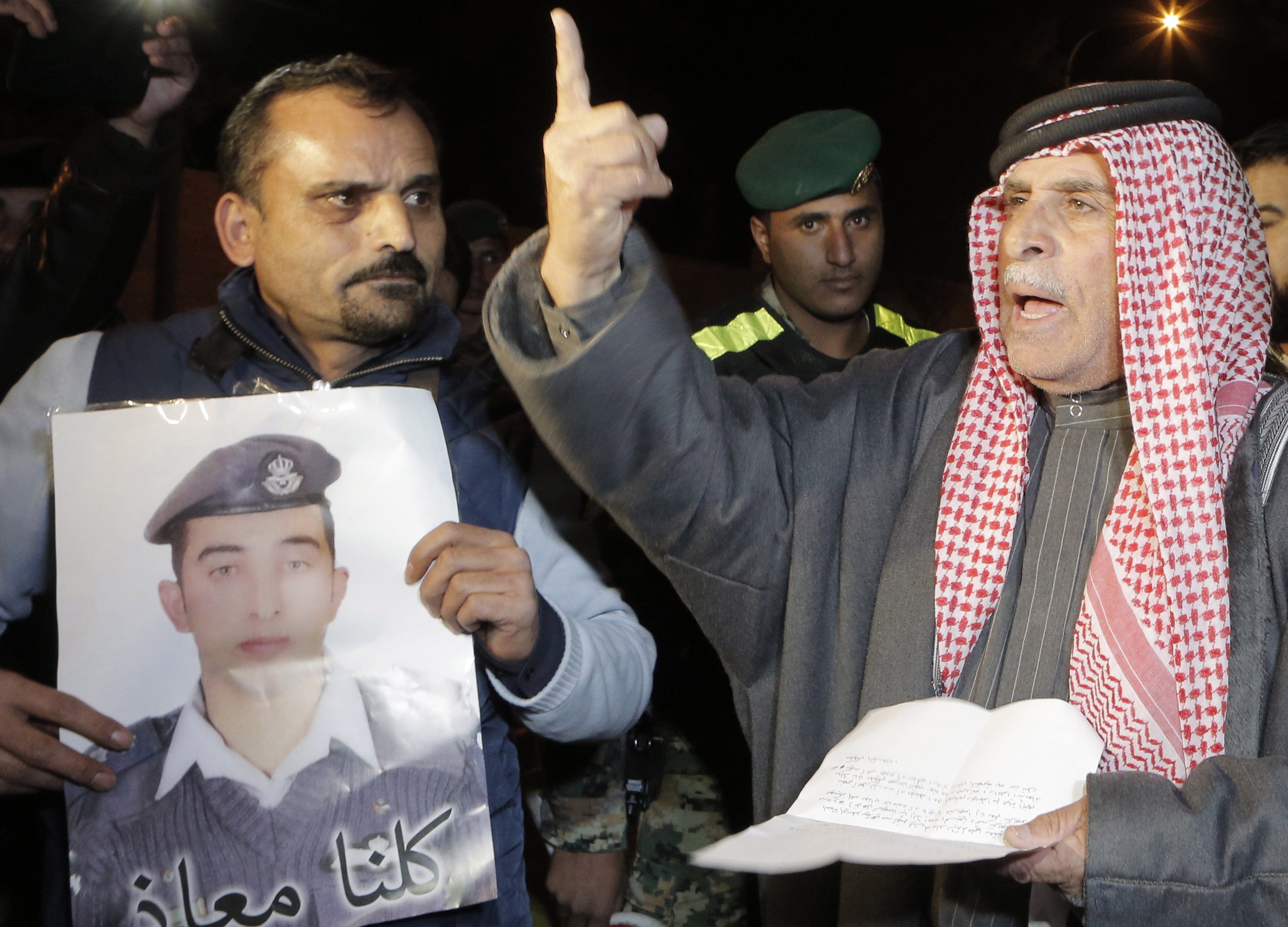 Safi al-Kasasbeh, right, the father of Jordanian pilot Moaz al-Kasasbeh (portrait), who was captured by ISIS militants on December 24, protests outside the Royal court in Amman on Jan. 28, 2015. (Khalil Mazraawi—AFP/Getty Images)