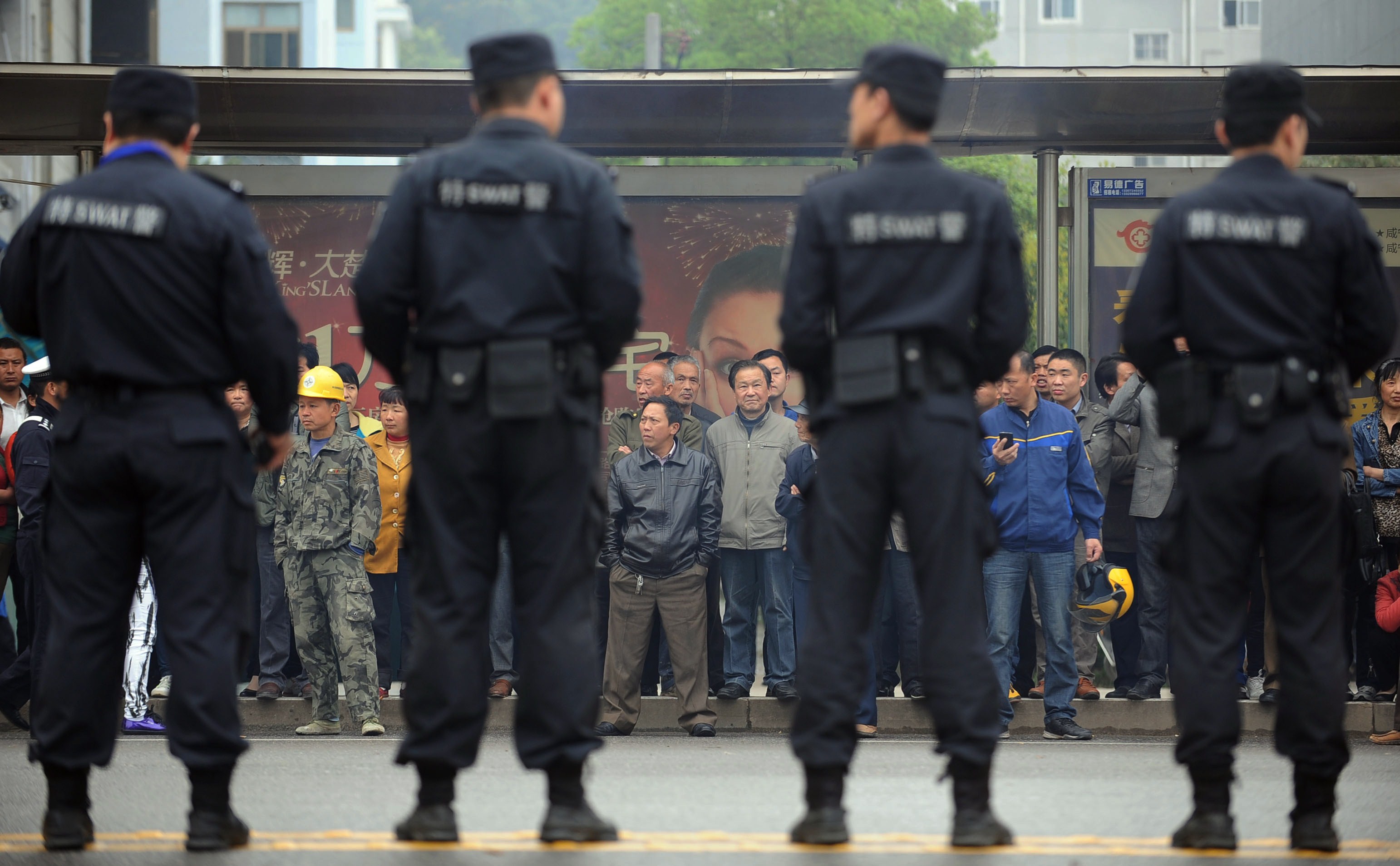 Citizens watch as police stand guard outside the Xianning Intermediate People's Court where Chinese mining tycoon Liu Han stands trial in Xianning, central China's Hubei province on March 31, 2014. (AFP&mdash;AFP/Getty Images)