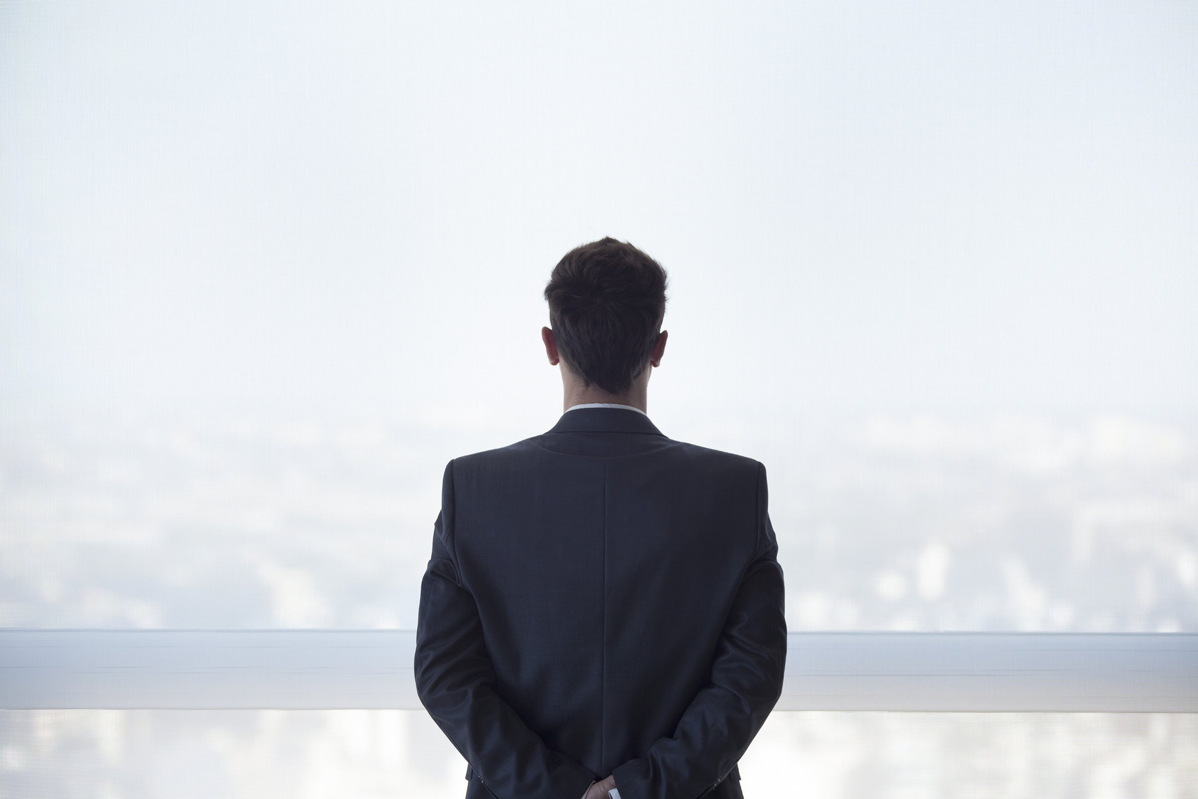 businessman-standing-looking-out-window